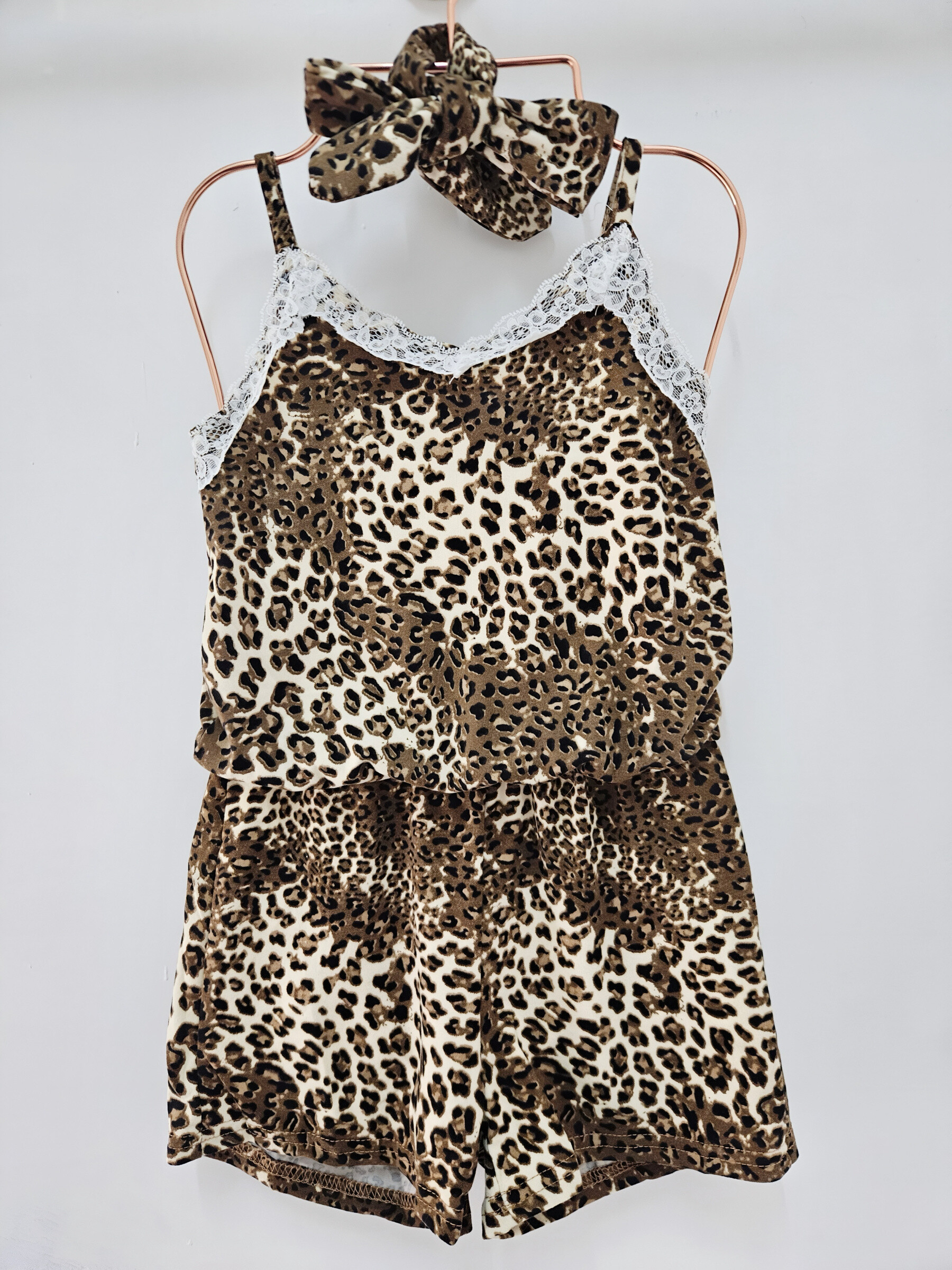 Grossista Chicaprie - Pagliaccetto da bambina fantasia leopardata con bretelle, inserti in pizzo e fascia per capelli