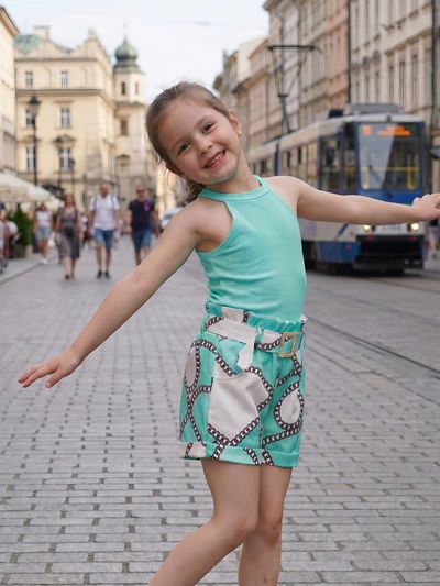 Großhändler Chicaprie - Mädchen-Set aus fließendem Uni-Top und Shorts mit urbanem Print-Gürtel Großhändler Chicaprie - Mädchen-Set aus fließendem Uni-Top und Shorts mit urbanem Print-Gürtel