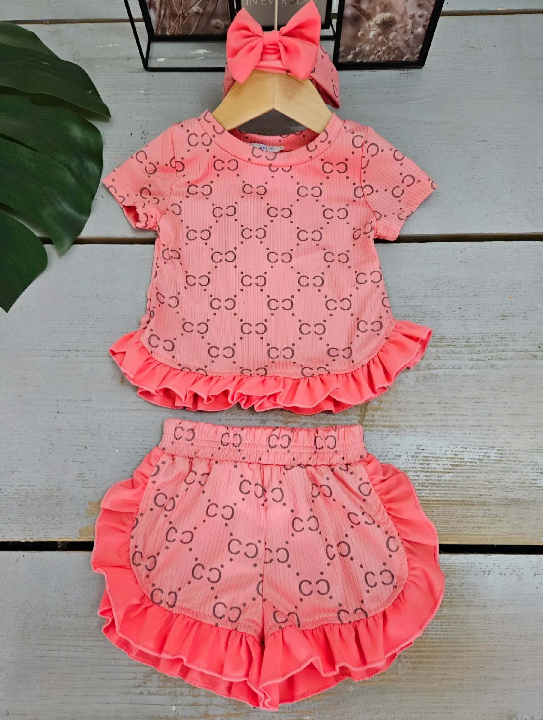 Grossista Chicaprie - Set Top E Shorts Con Volant E Stampa, Fascia Per Capelli Con Fiocco Per Bambina