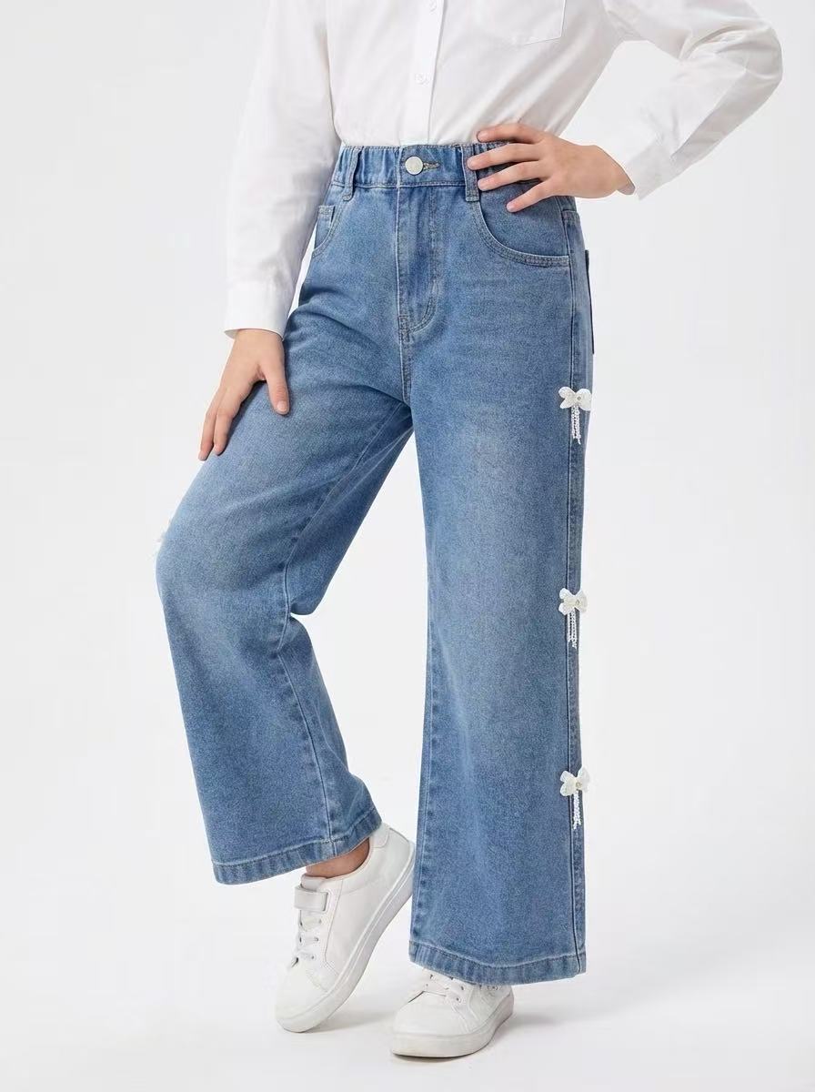 Mayorista Fiona & Co - Vaqueros anchos azules para niña con detalles de lazos Mayorista Fiona & Co - Vaqueros anchos azules para niña con detalles de lazos