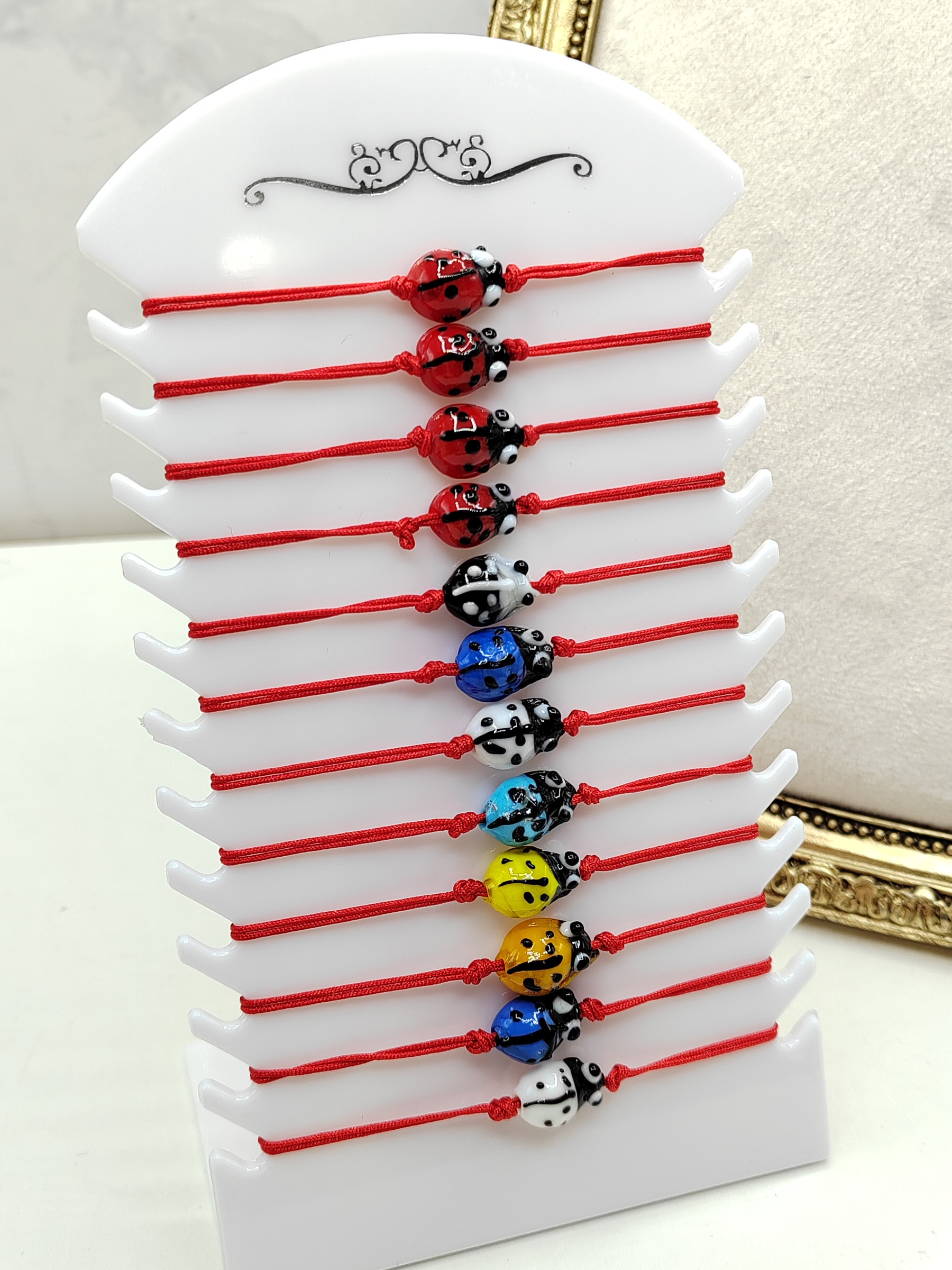 Grossiste I.L JOLI B - Plaquette de 12 bracelets rouge réglable pour enfant coccinelle