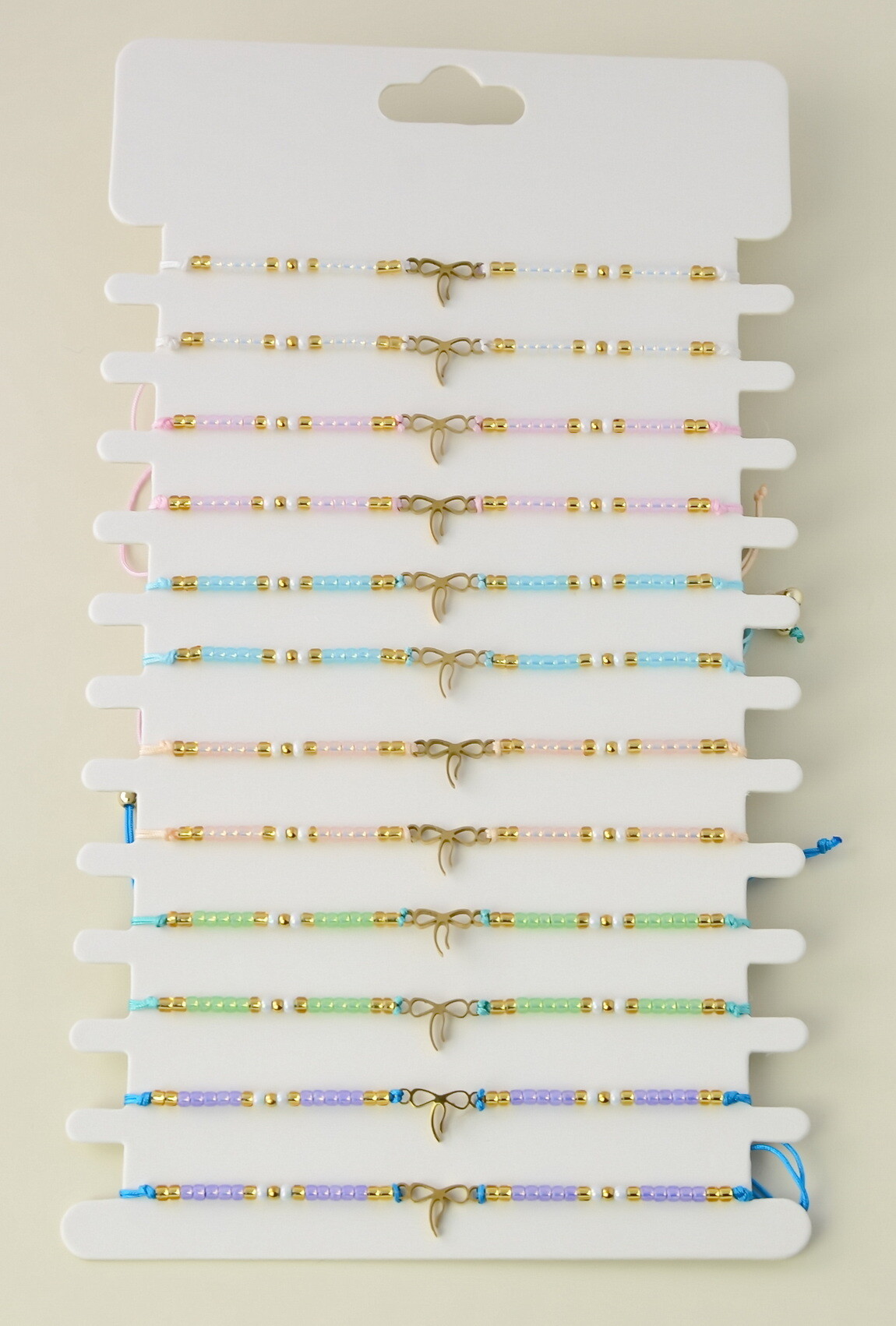 Grossiste LILY CONTI - Lot de 12 bracelets ajustables en acier inoxydable doré et perles rocailles