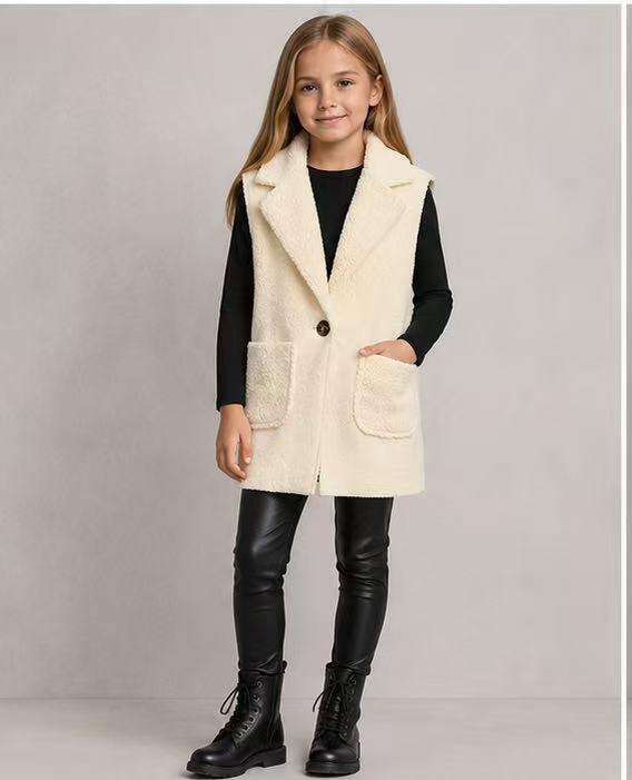 Grossiste Tiffany fashion - Gilet effet mouton pour fille. Doux, chaud et super tendance, avec un revers élégant, fermeture à bouton et poches frontales pratiques.