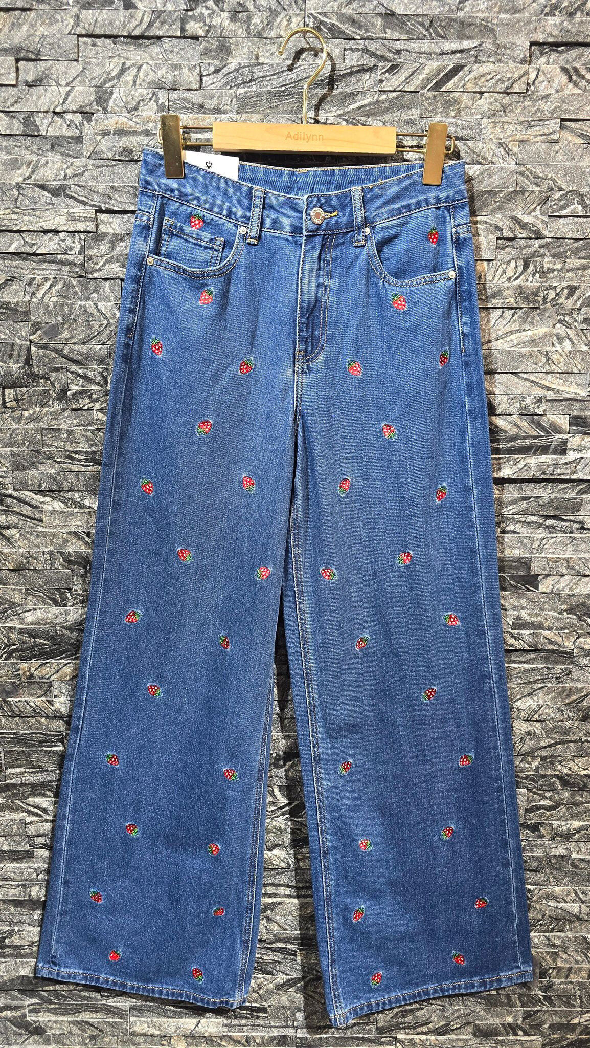 Grossiste Adilynn - Jeans large broderies fraises, fermeture à zip et boutons, cinq poches