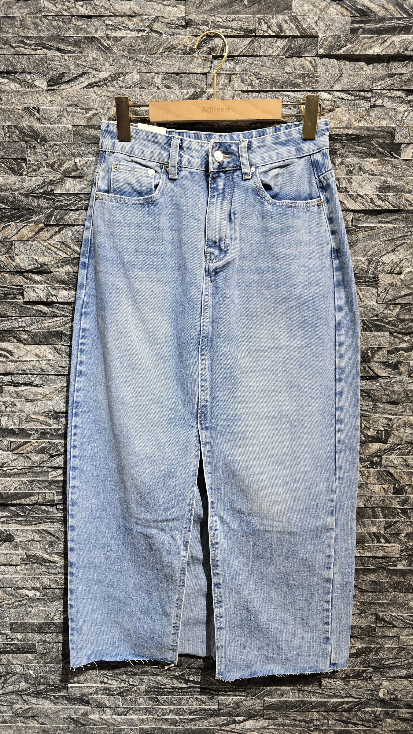 Grossiste Adilynn - Jupe en jeans fendue sur l'avant, fermeture à zip et bouton, cinq poches