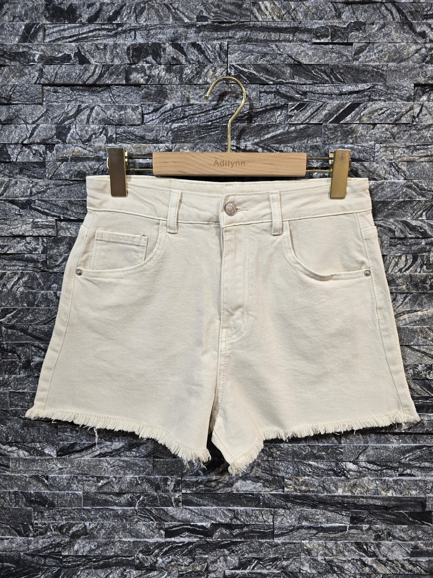 Grossista Adilynn - Short in denim bianco sporco, orlo sfilacciato, chiusura con zip e bottone, cinque tasche