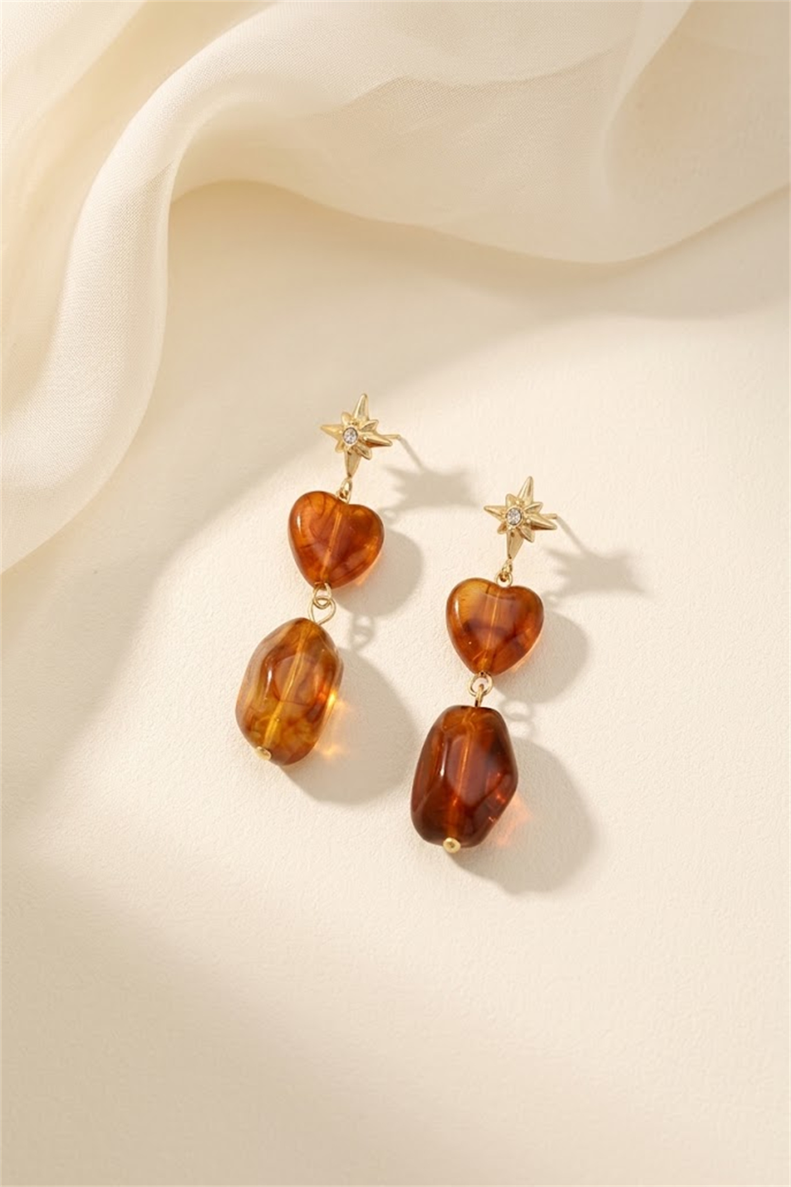 Grossiste Bellissima - Boucles d’oreilles étoiles et cœurs résine effet ambre acier inoxydable