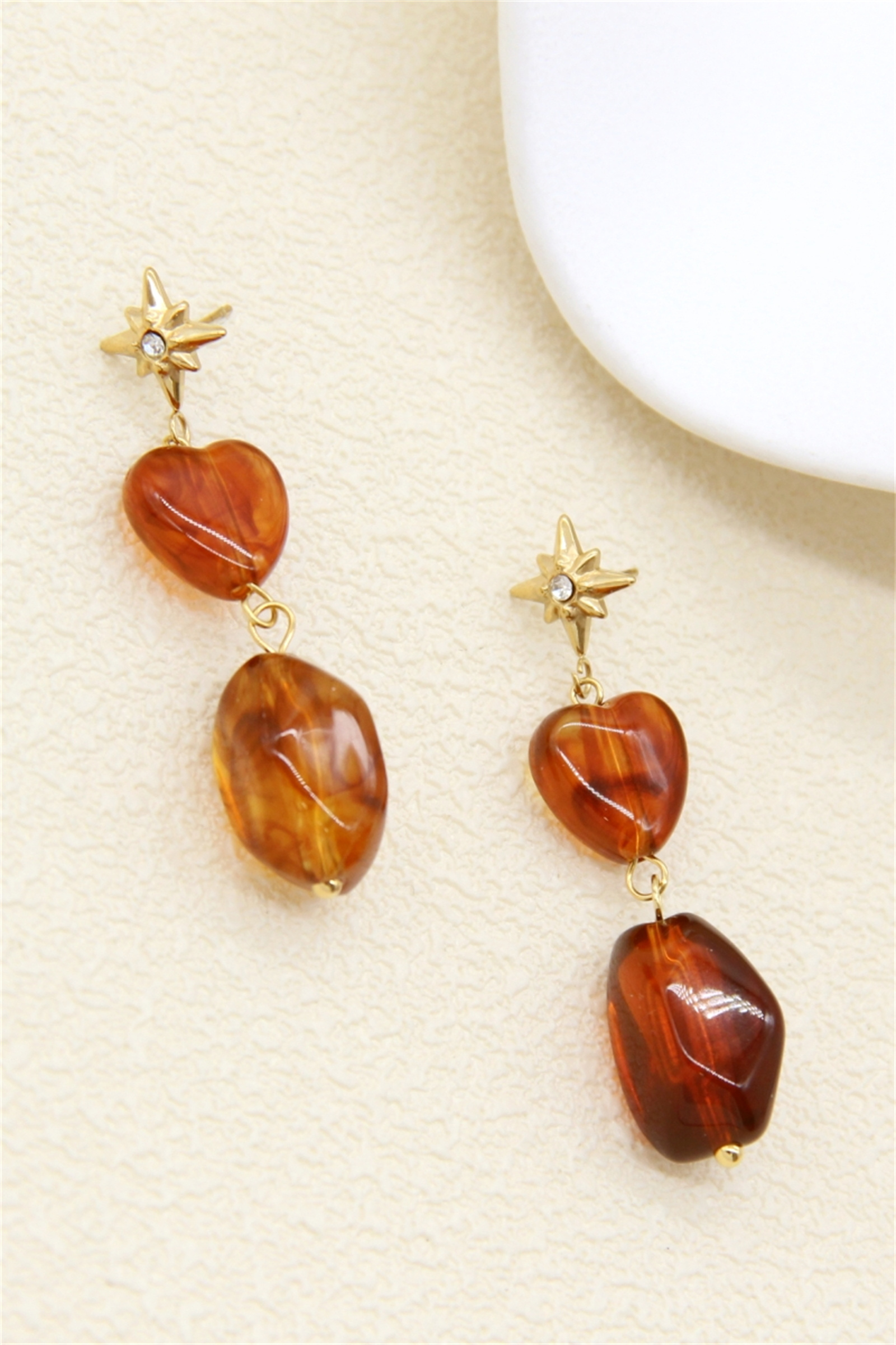 Grossiste Bellissima - Boucles d’oreilles étoiles et cœurs résine effet ambre acier inoxydable
