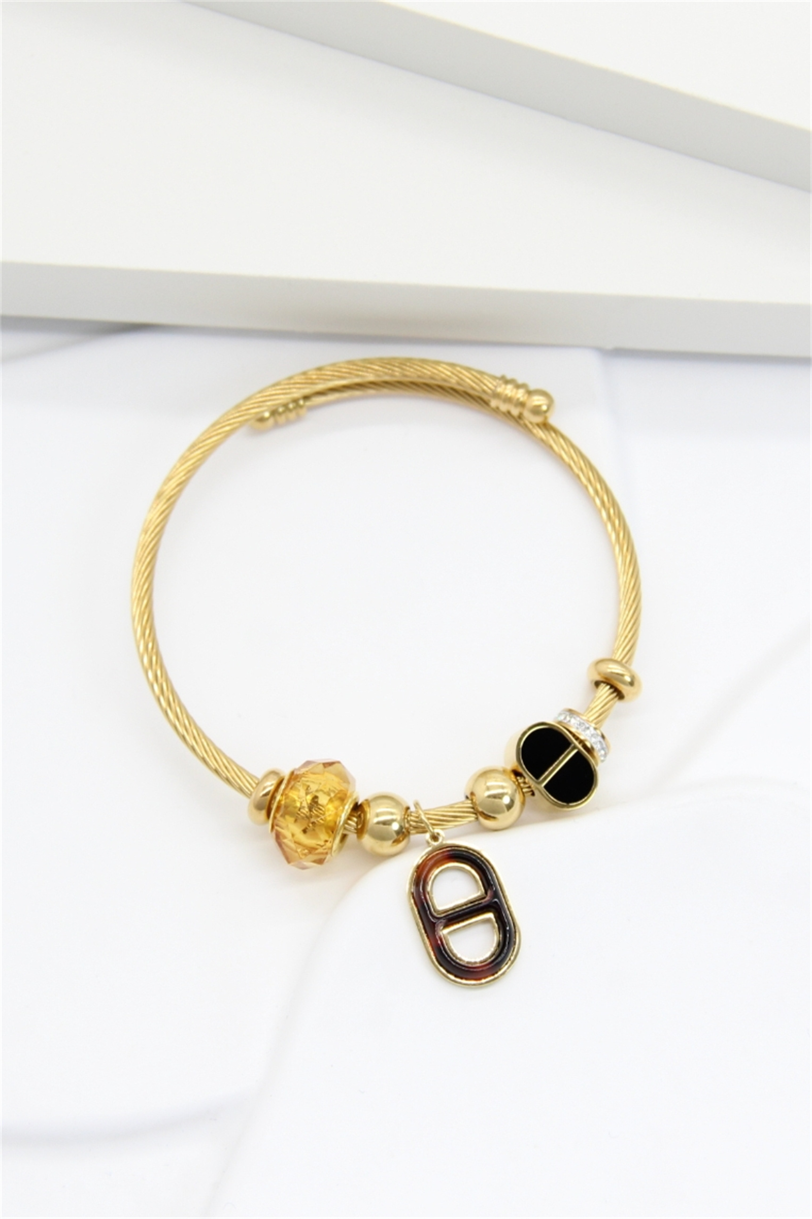 Grossiste Bellissima - Bracelet Doré à Breloques Fantaisie – Câble Rigide et Perles Élégantes