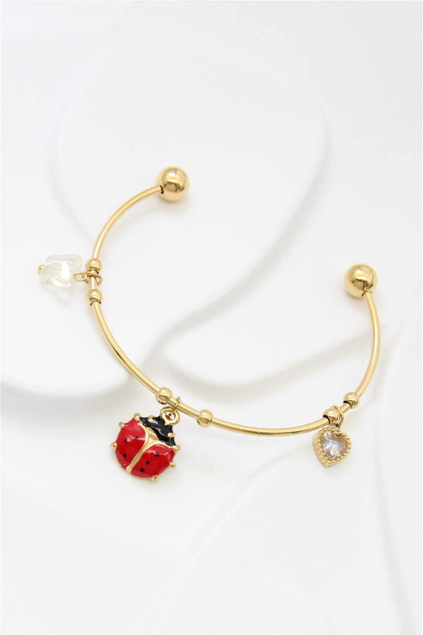 Grossiste Bellissima - Bracelet jonc doré en acier inoxydable avec breloques coccinelle et cœur
