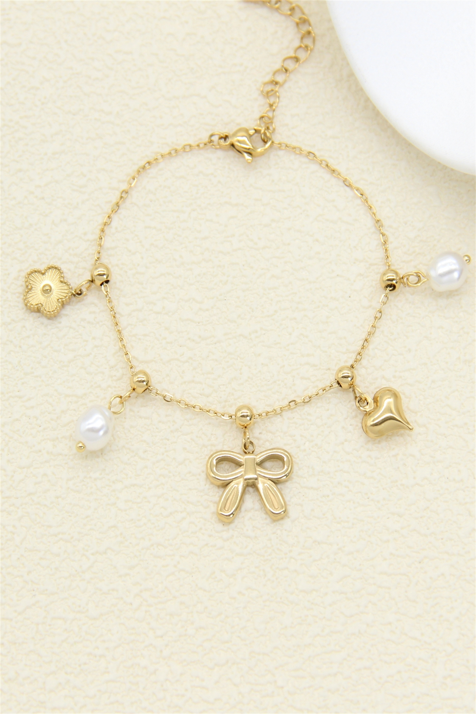 Mayorista Bellissima - Pulsera de Charms Dorada para Mujer – Lazo, Perla y Corazón
