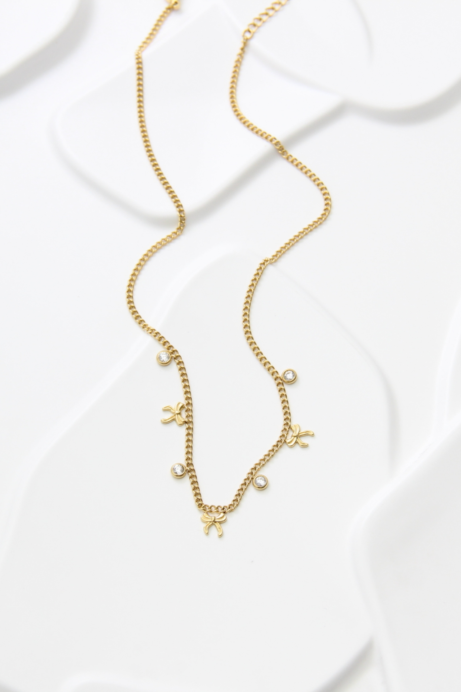 Grossiste Bellissima - Collier en acier inoxydable doré avec pampilles nœuds et strass
