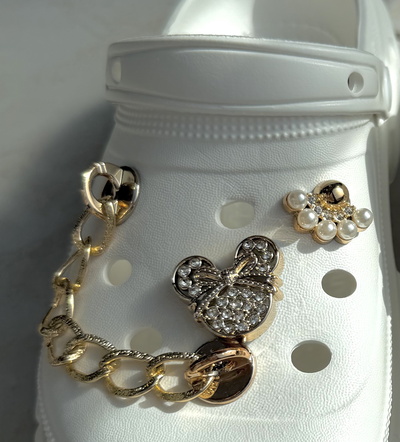 Großhändler C&C Chaussures - Goldene Pins für gelochte EVA-Schuhe Großhändler C&C Chaussures - Goldene Pins für gelochte EVA-Schuhe