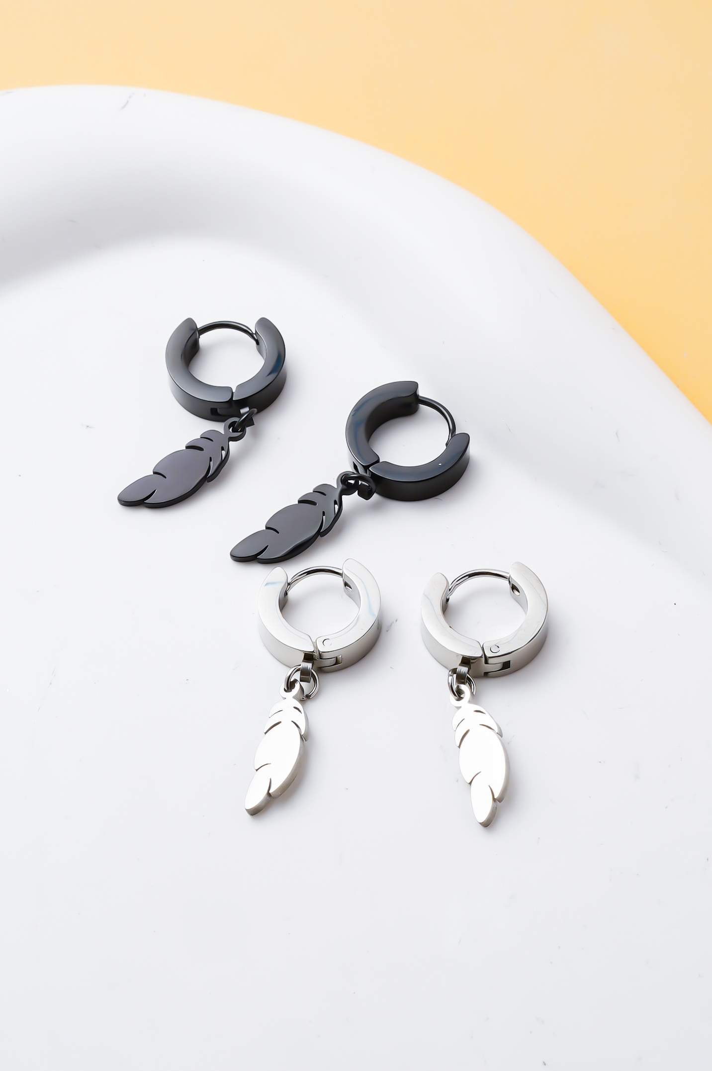 Grossiste Ceramik - Boucles d’oreilles femme créoles plume acier inoxydable noir ou argent au choix