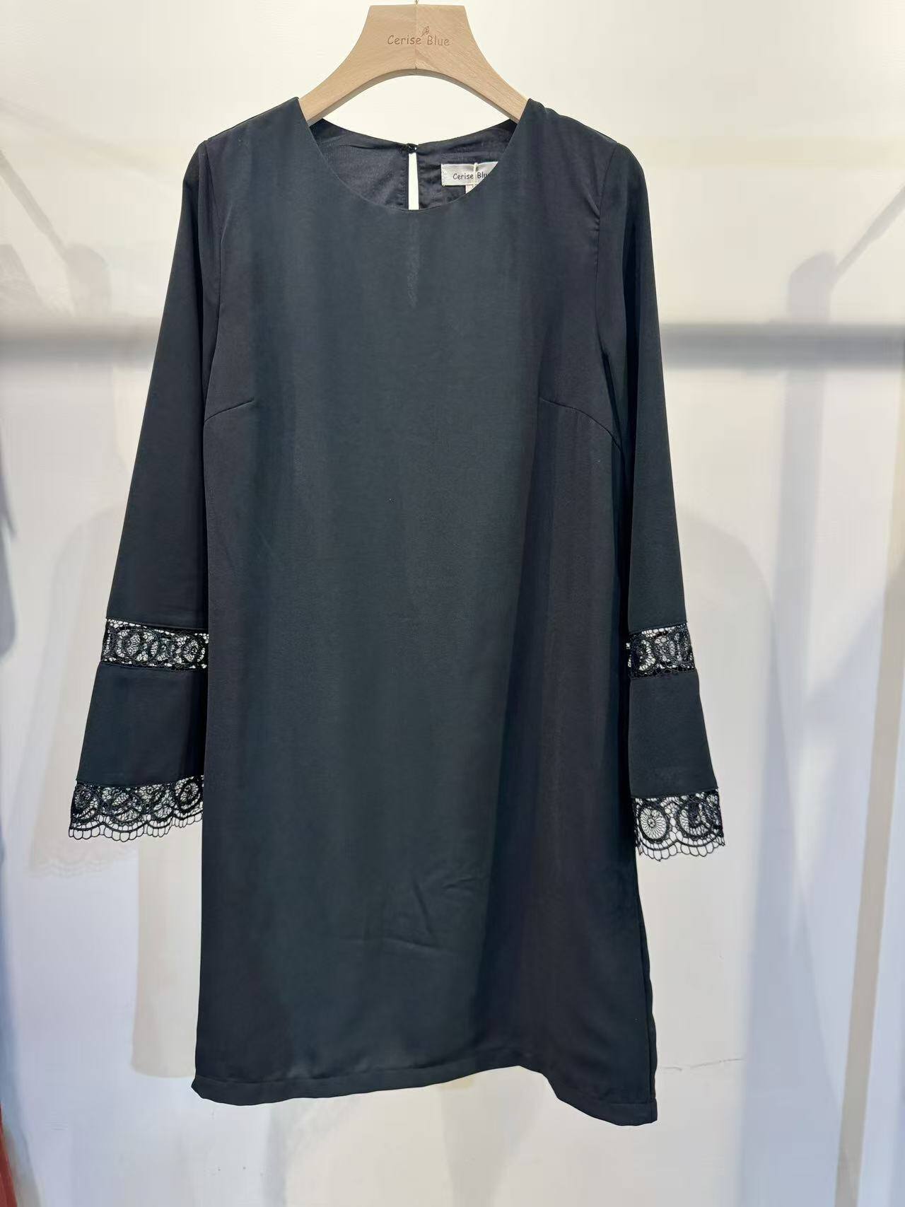 Robe noire élégante, coupe droite, manches en dentelle raffinée. Idéale pour l'automne/hiver, composée de polyester et d'élasthanne. Fabriquée en Chine.