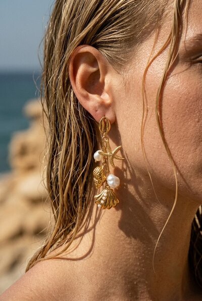 Grossiste COSMOS - Boucles marine dorées acier inoxydable cauri coquillages perles étoile mer élégantes Grossiste COSMOS - Boucles marine dorées acier inoxydable cauri coquillages perles étoile mer élégantes