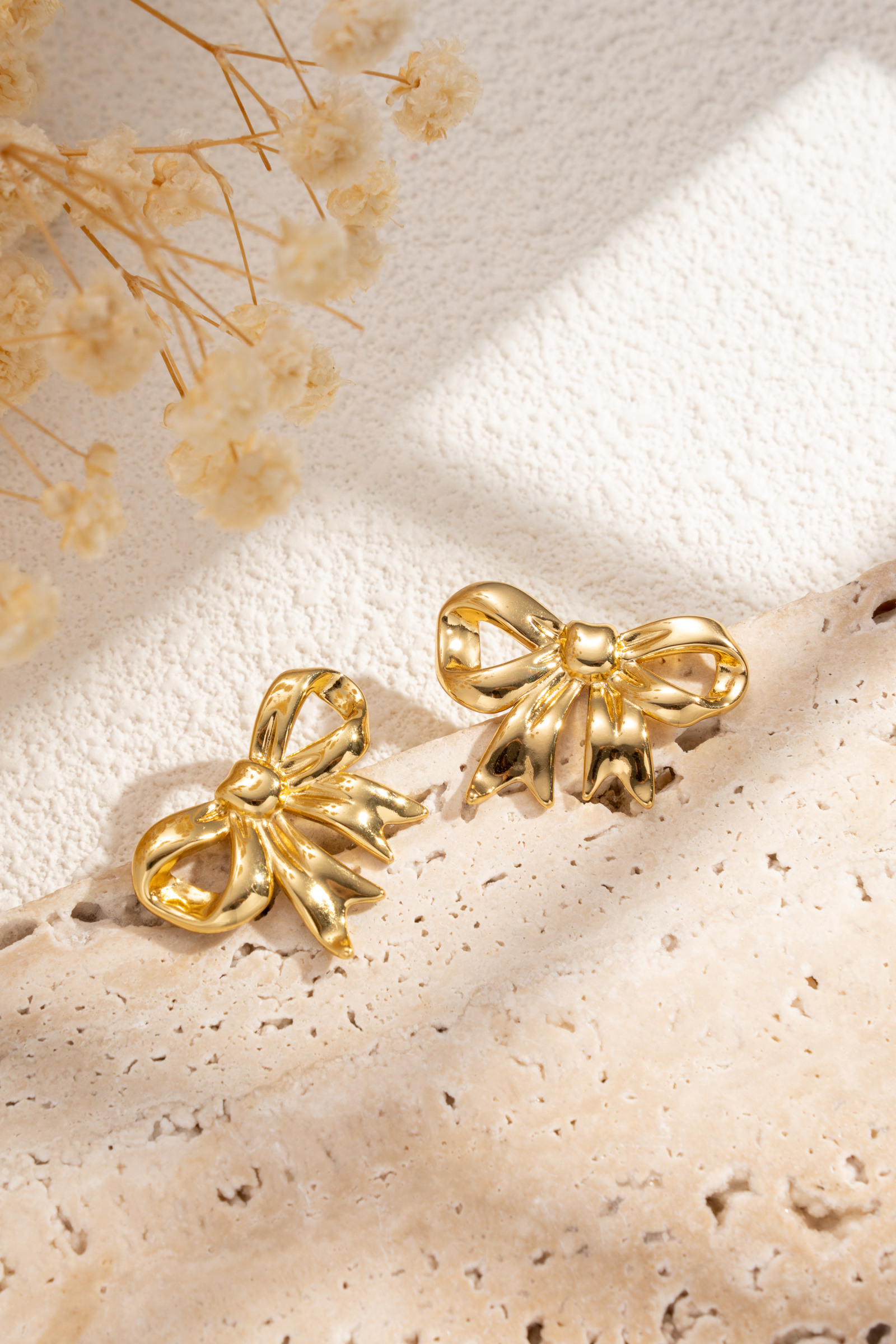 Wholesaler COSMOS - Women's gold knot earrings in stainless steel with chic, elegant, trendy, and shiny ribbon