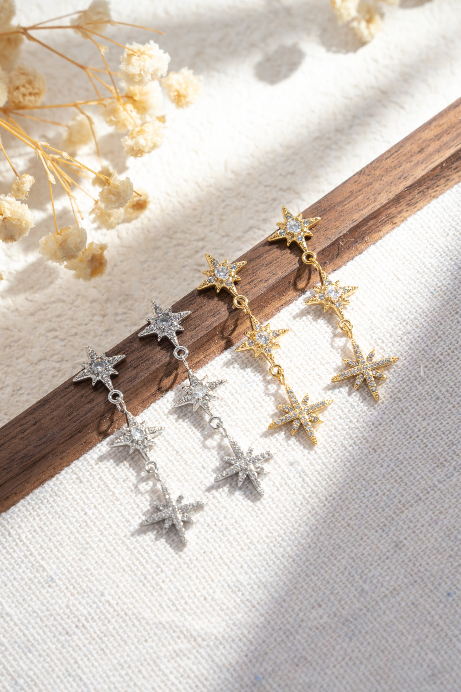 Grossista COSMOS - Set di 2 paia di orecchini a forma di stella con strass dorati e argentati, eleganti