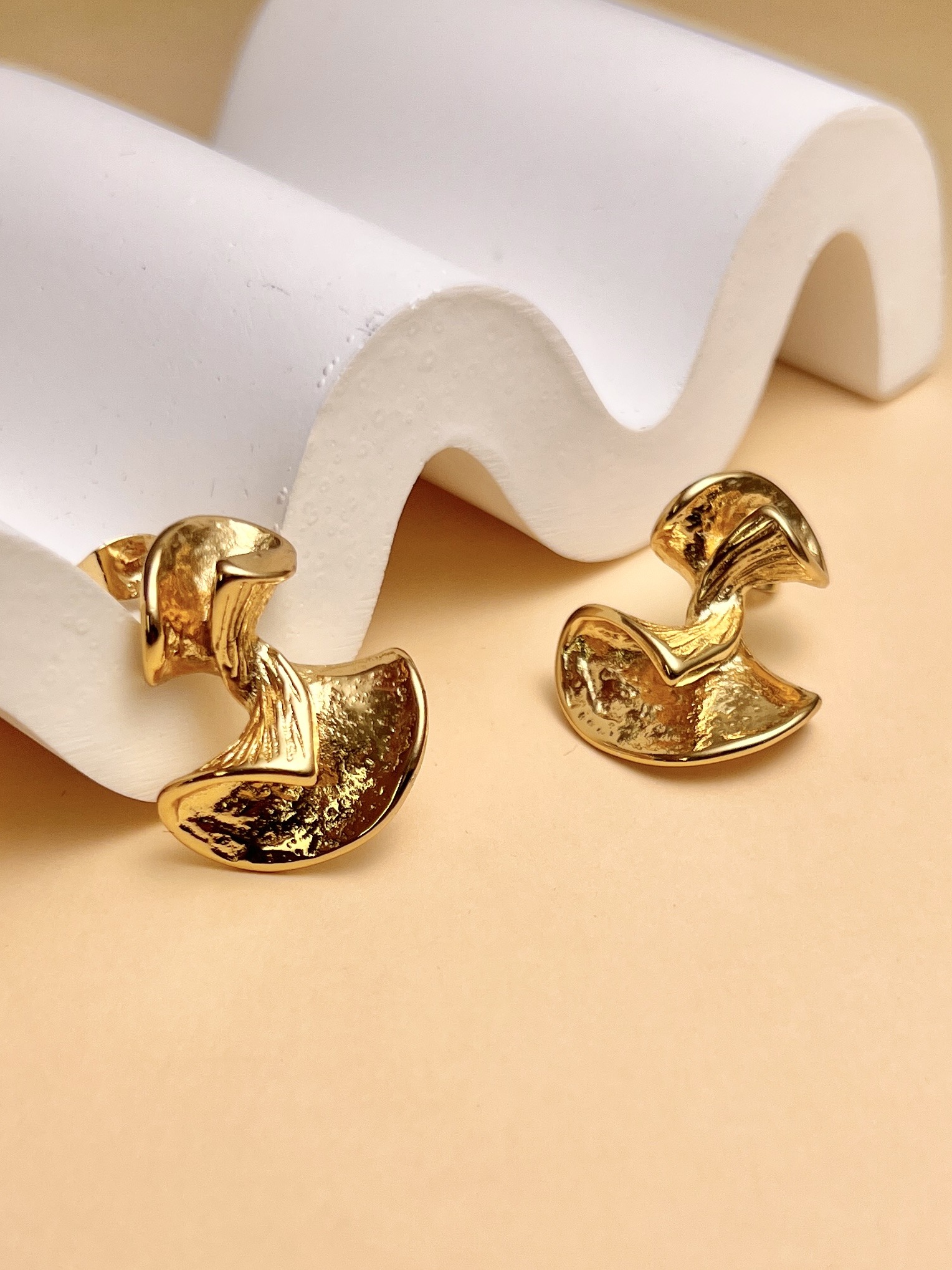 Grossiste COSMOS - Boucles d’oreilles dorées fluides en acier inoxydable texturé