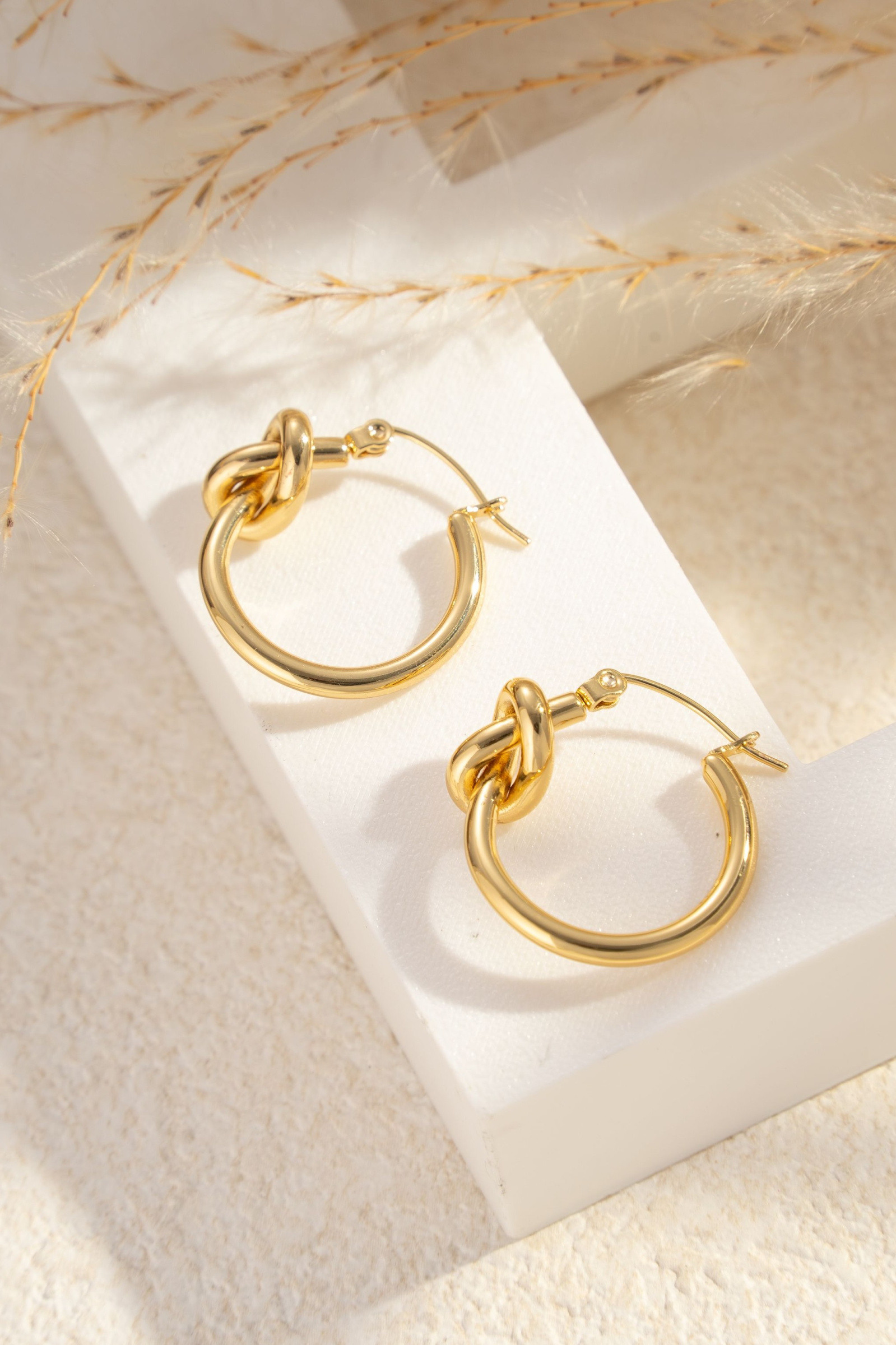 Wholesaler COSMOS - Gold stainless steel hoop earrings, elegant knot design, shiny and chic finish