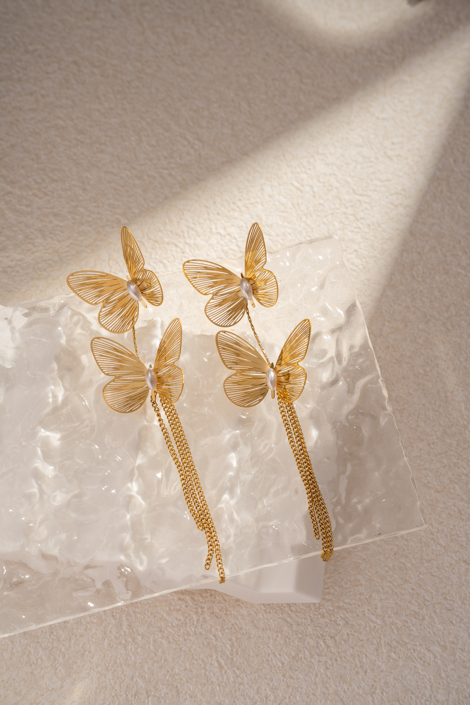 Grossiste COSMOS - Boucles d’oreilles papillon doré élégantes avec chaînes pendantes