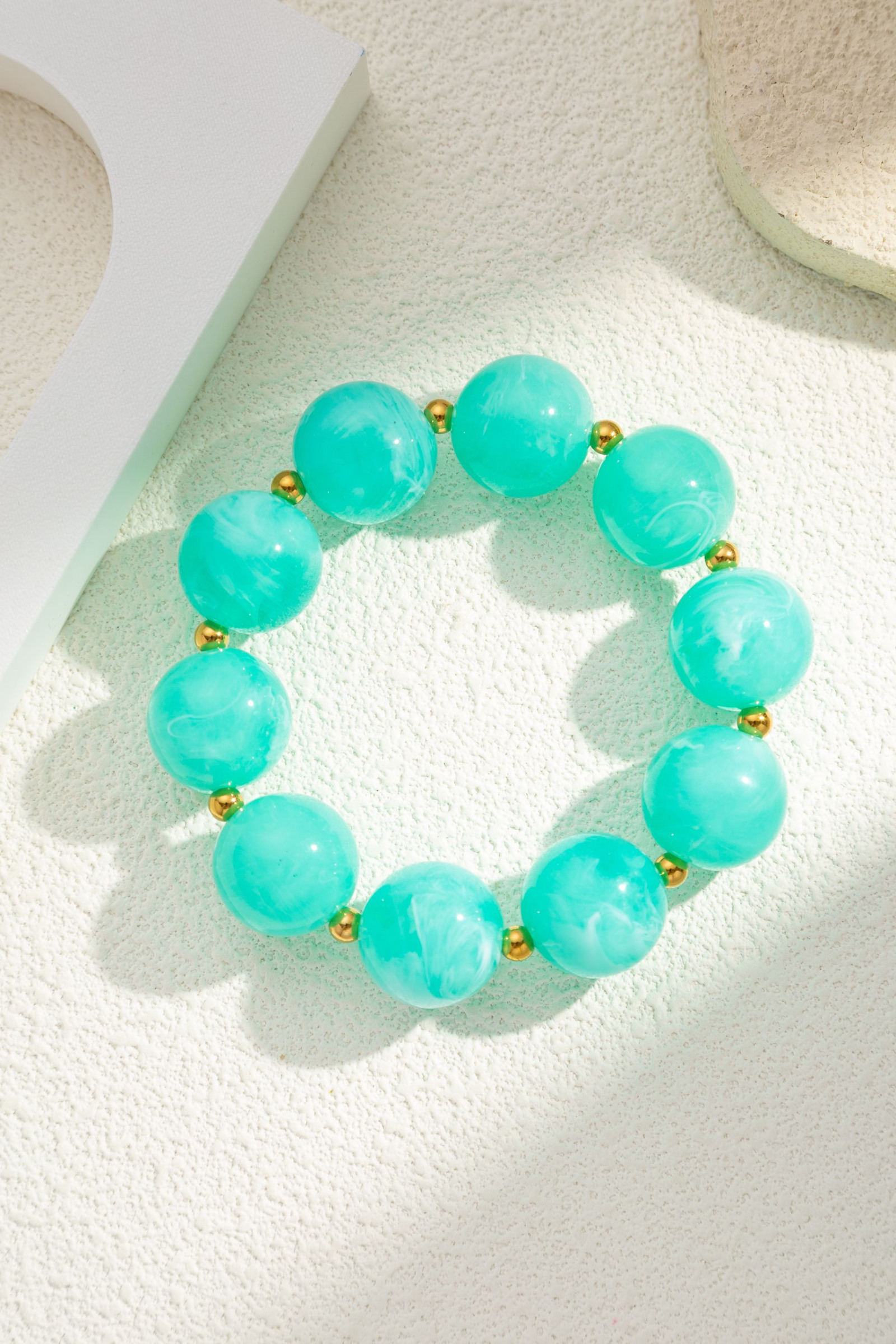 Grossiste COSMOS - Bracelet résine turquoise marbrée acier inoxydable doré perles rondes élastique