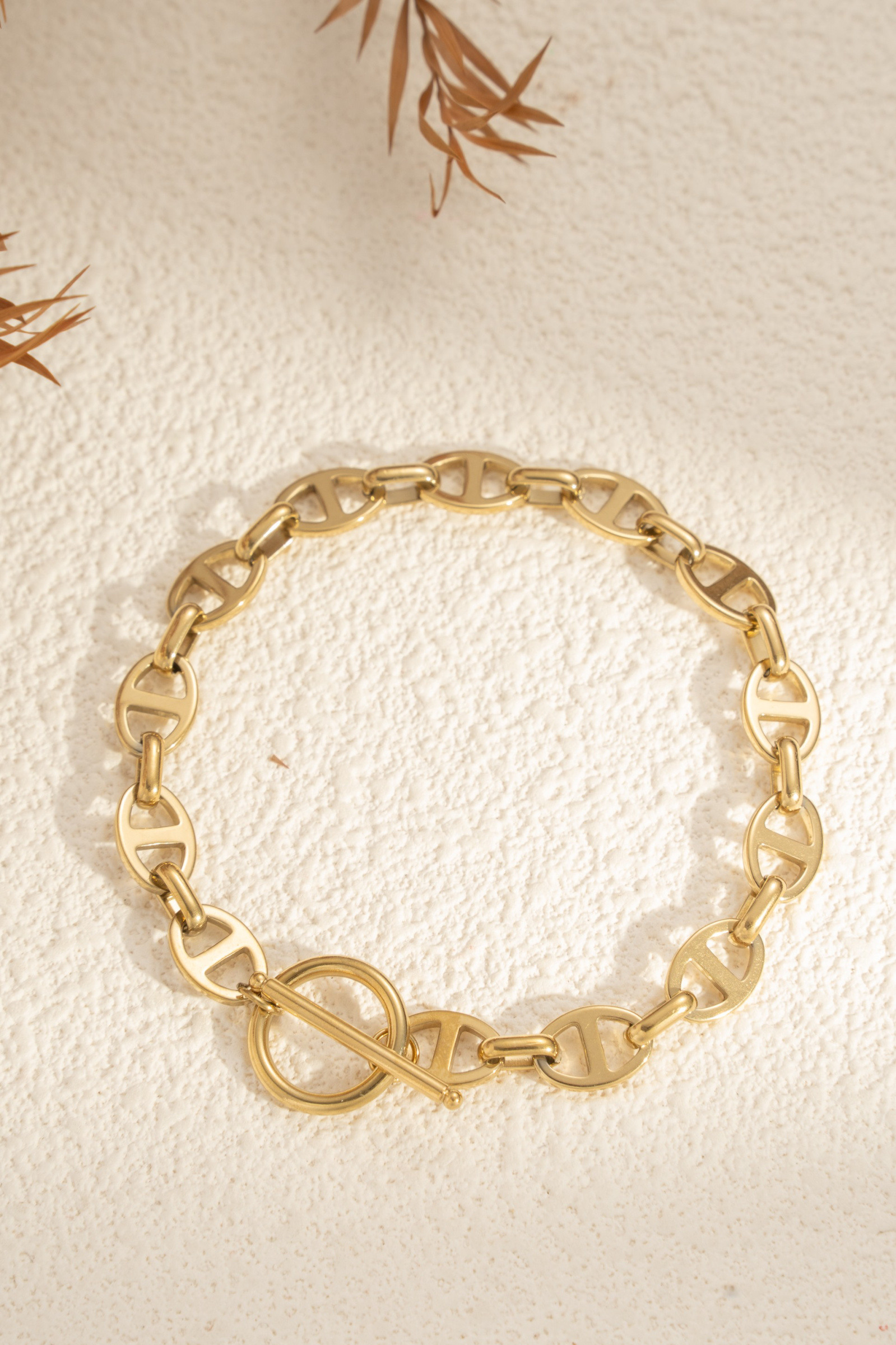 Grossista COSMOS - Bracciale dorato con maglie traforate in acciaio inossidabile, chiusura toggle moderna, elegante e chic