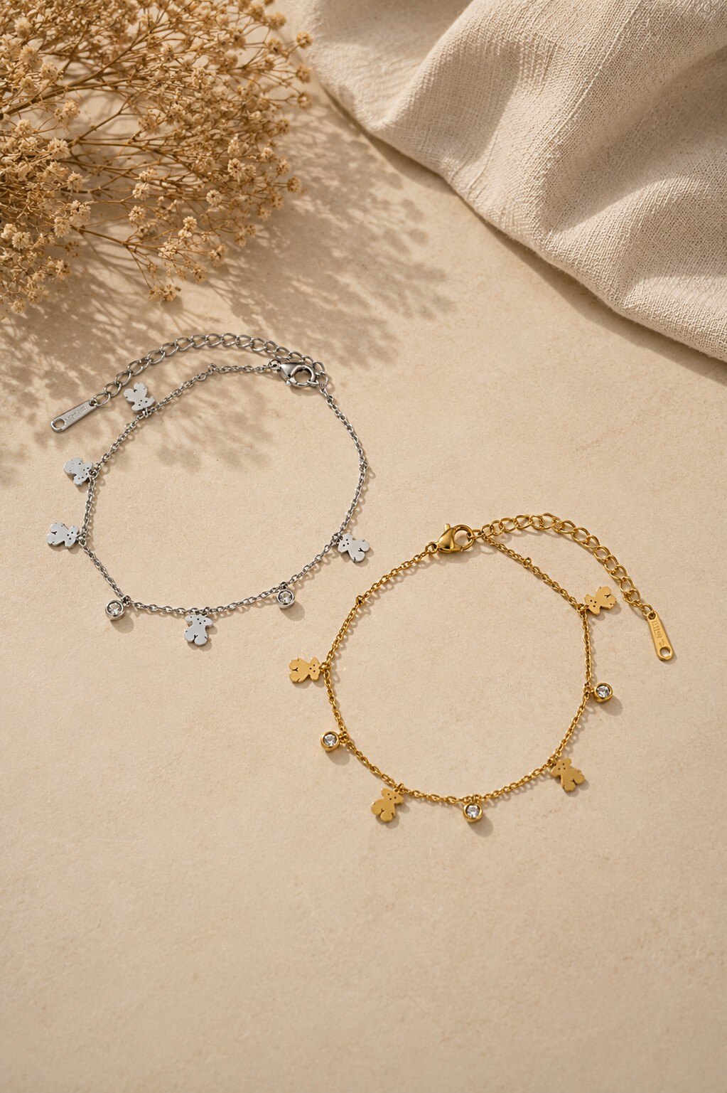 Grossista COSMOS - Set di due braccialetti in acciaio inossidabile dorato e argentato con un delicato motivo di orsetto
