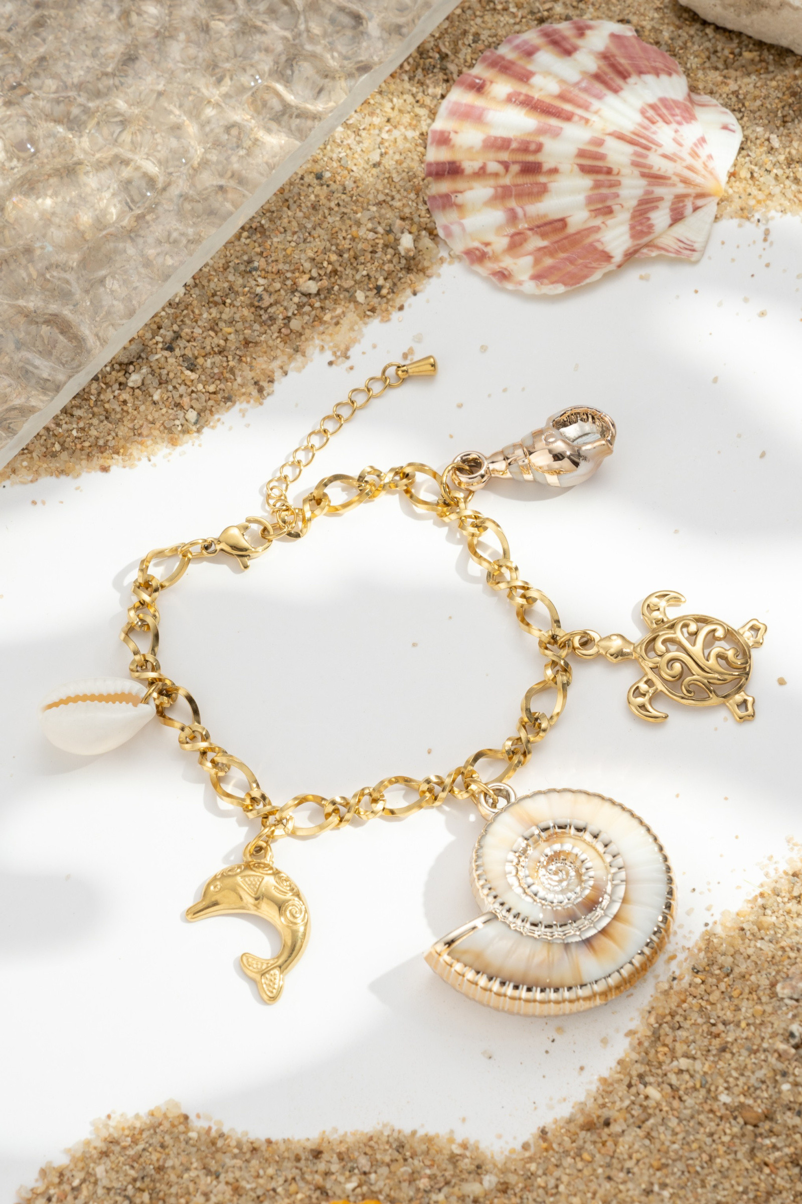 Großhändler COSMOS - Ozean-Charms-Armband mit Delfin, Schildkröte, Muscheln und Spirale aus vergoldetem Edelstahl