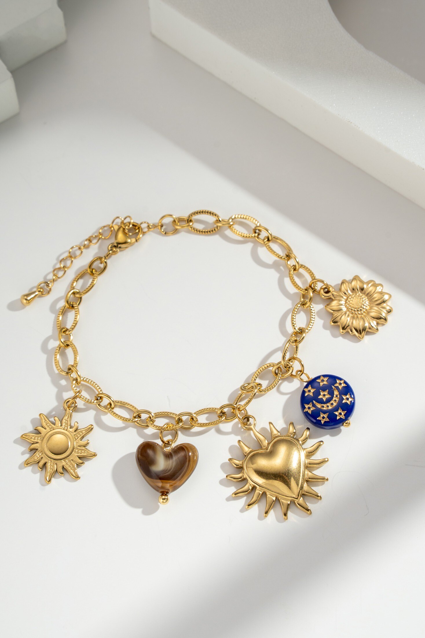 Wholesaler COSMOS - Gold stainless steel bracelet for women with sun, heart, moon, and star charms, adjustable chain, boho chic