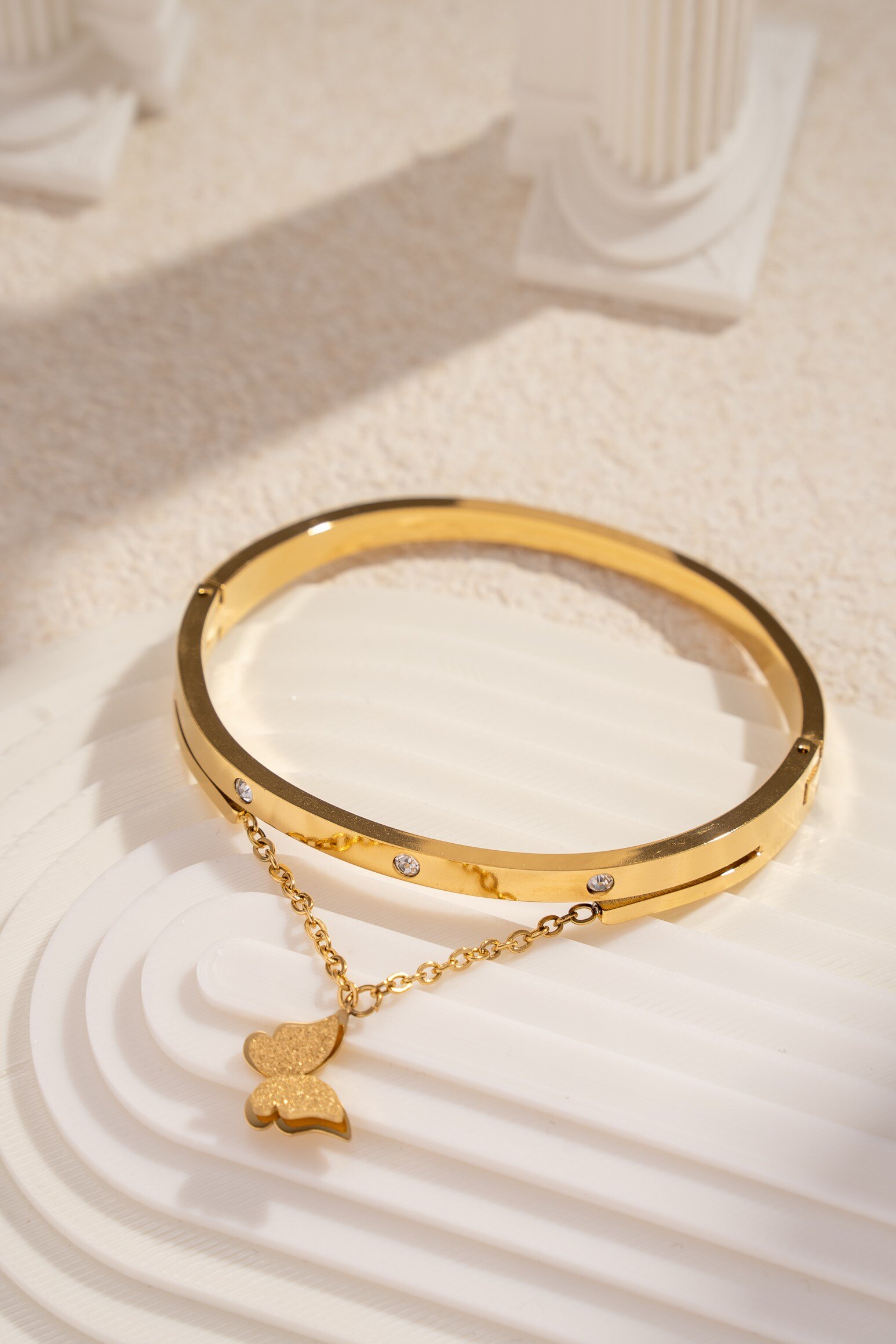 Grossista COSMOS - Bracciale Dorato con Farfalla Intagliata e Pietre Eleganza Femminile Moderna Chic