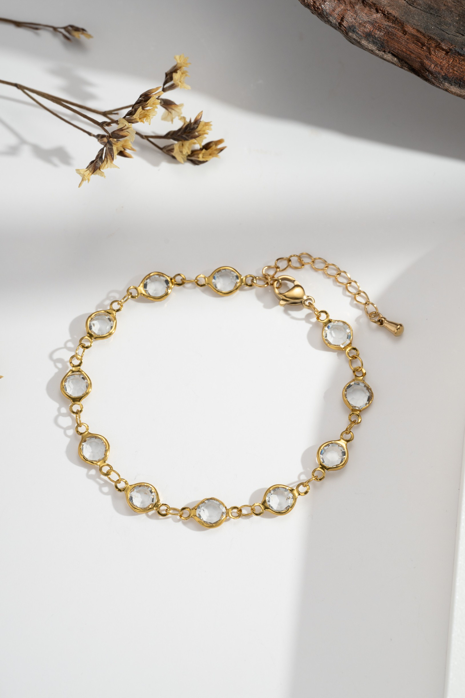 Großhändler COSMOS - Damenarmband mit transparenten Steinen aus vergoldetem Edelstahl, zart, leuchtend, elegant, modisch