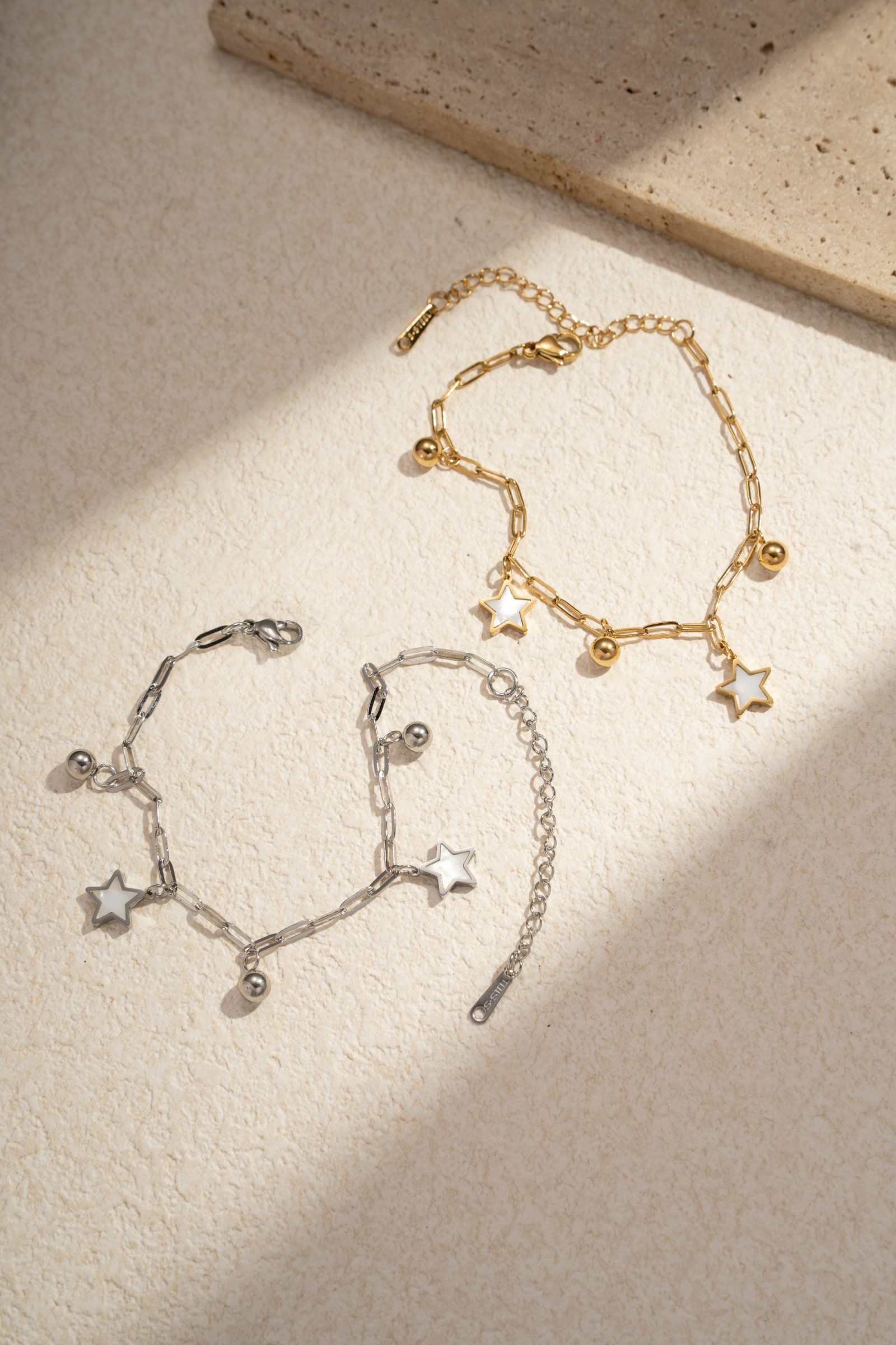 Grossista COSMOS - Set di 2 braccialetti in acciaio inossidabile dorato e argentato con motivi a stella e ciondoli delicati