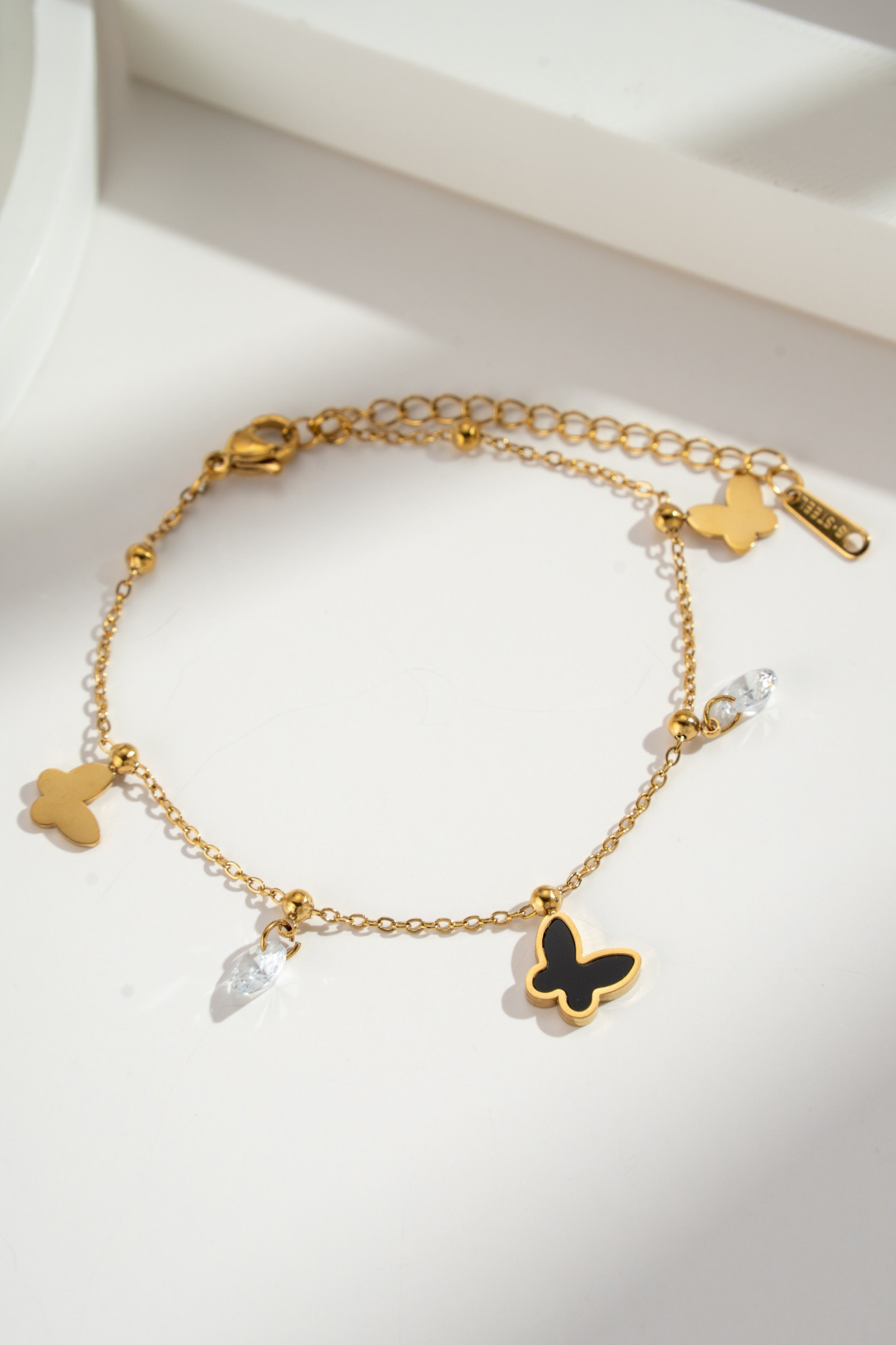 Großhändler COSMOS - Goldenes Armband mit schwarzem Schmetterling und klaren Kristallen, edler verstellbarer Schmuck