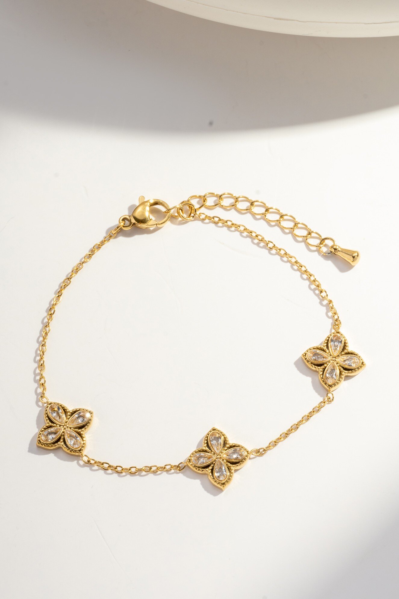 Wholesaler COSMOS - Elegant adjustable gold-plated stainless steel bracelet for women with floral motif and teardrop stones