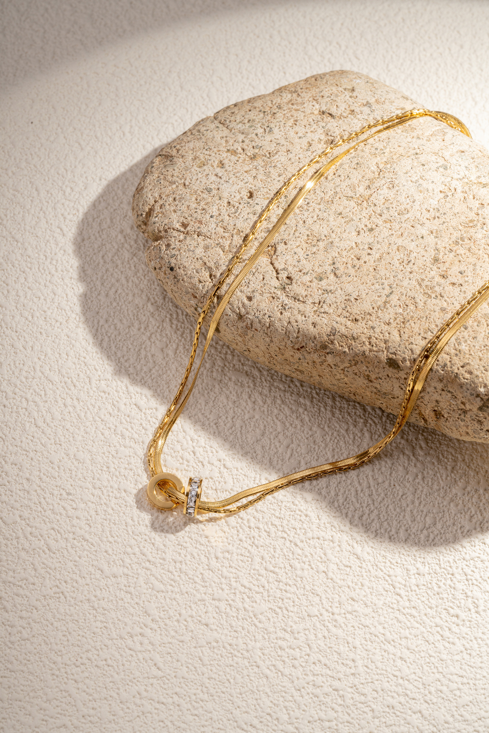 Wholesaler COSMOS - Gold-plated stainless steel necklace with a textured and shiny double ring pendant