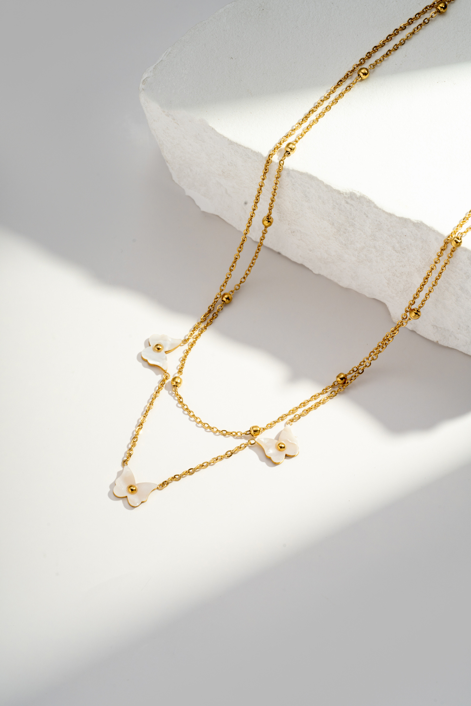 Grossiste COSMOS - Collier double rang en acier inoxydable avec pendentifs fleurs en nacre