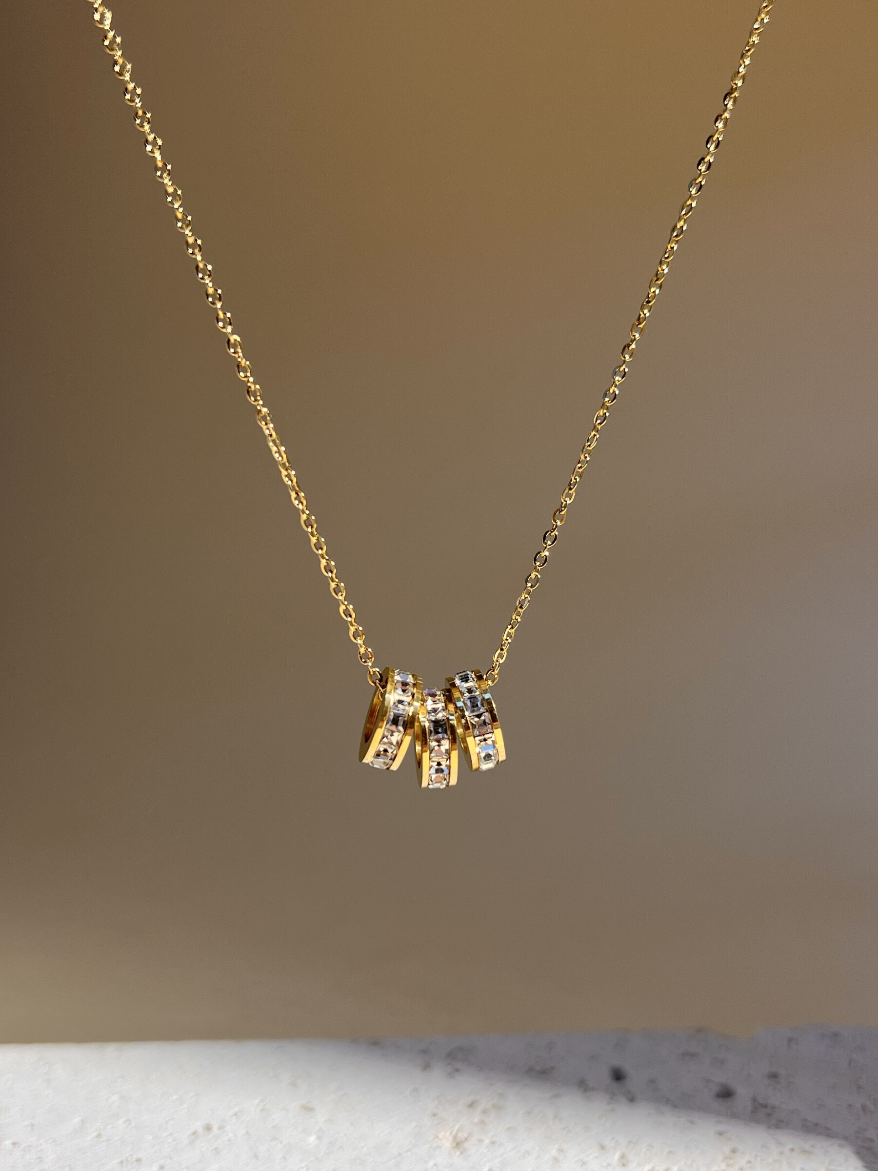 Grossista COSMOS - Collana raffinata con 3 anelli di strass, catena in acciaio inossidabile elegante, minimalista.