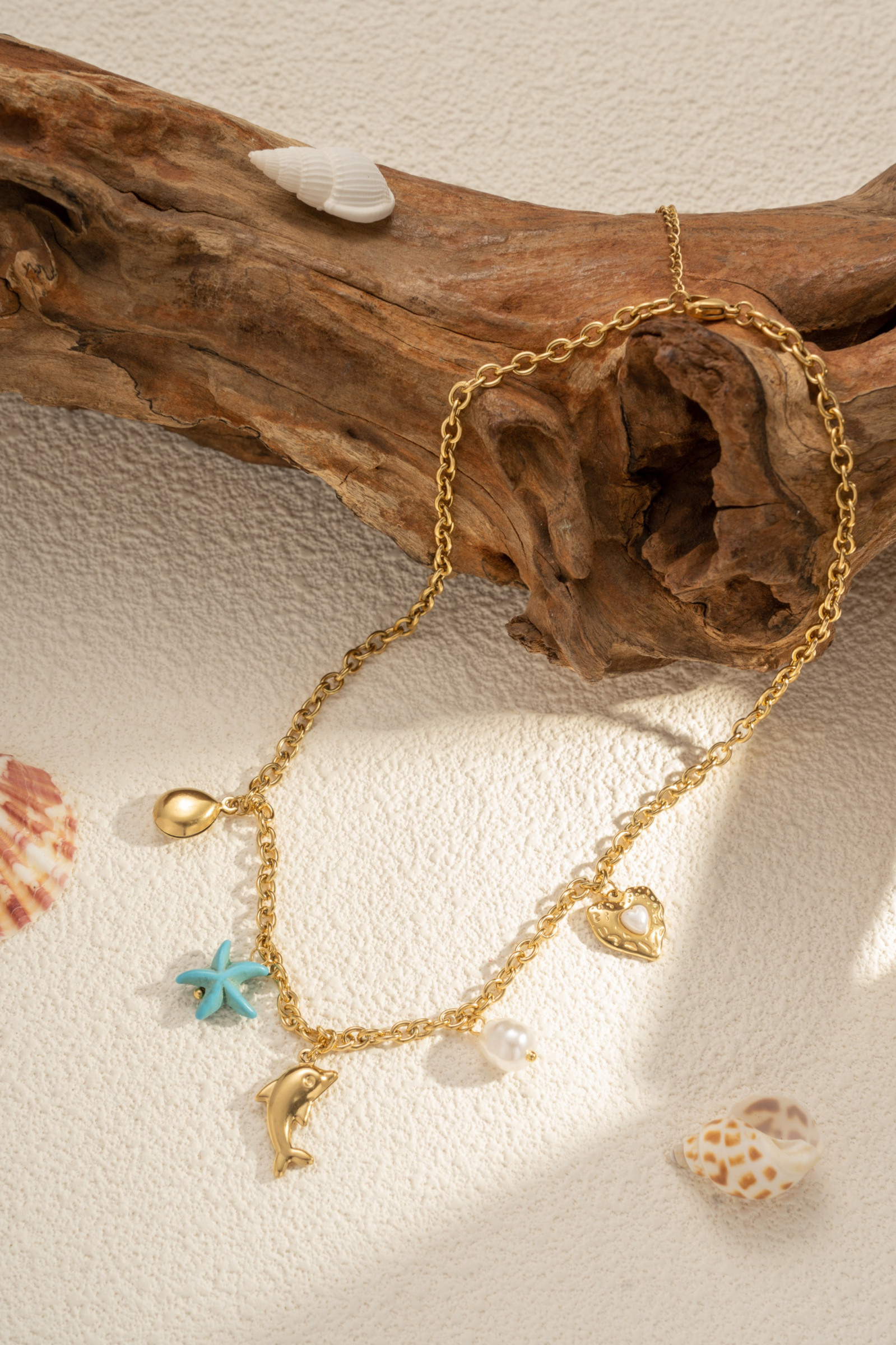 Grossista COSMOS - Collana dorata con charms marini stella turchese delfino perla cuore acciaio inossidabile chic
