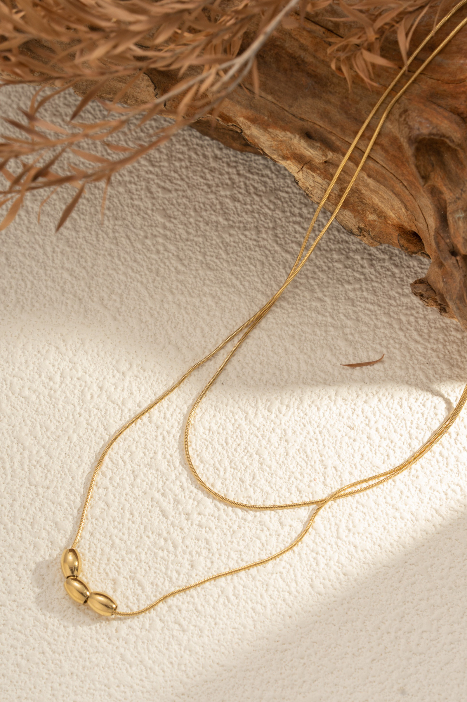 Grossista COSMOS - Collana dorata con tre perle ovali in acciaio inossidabile, minimalista, elegante, raffinata, moderna, chic