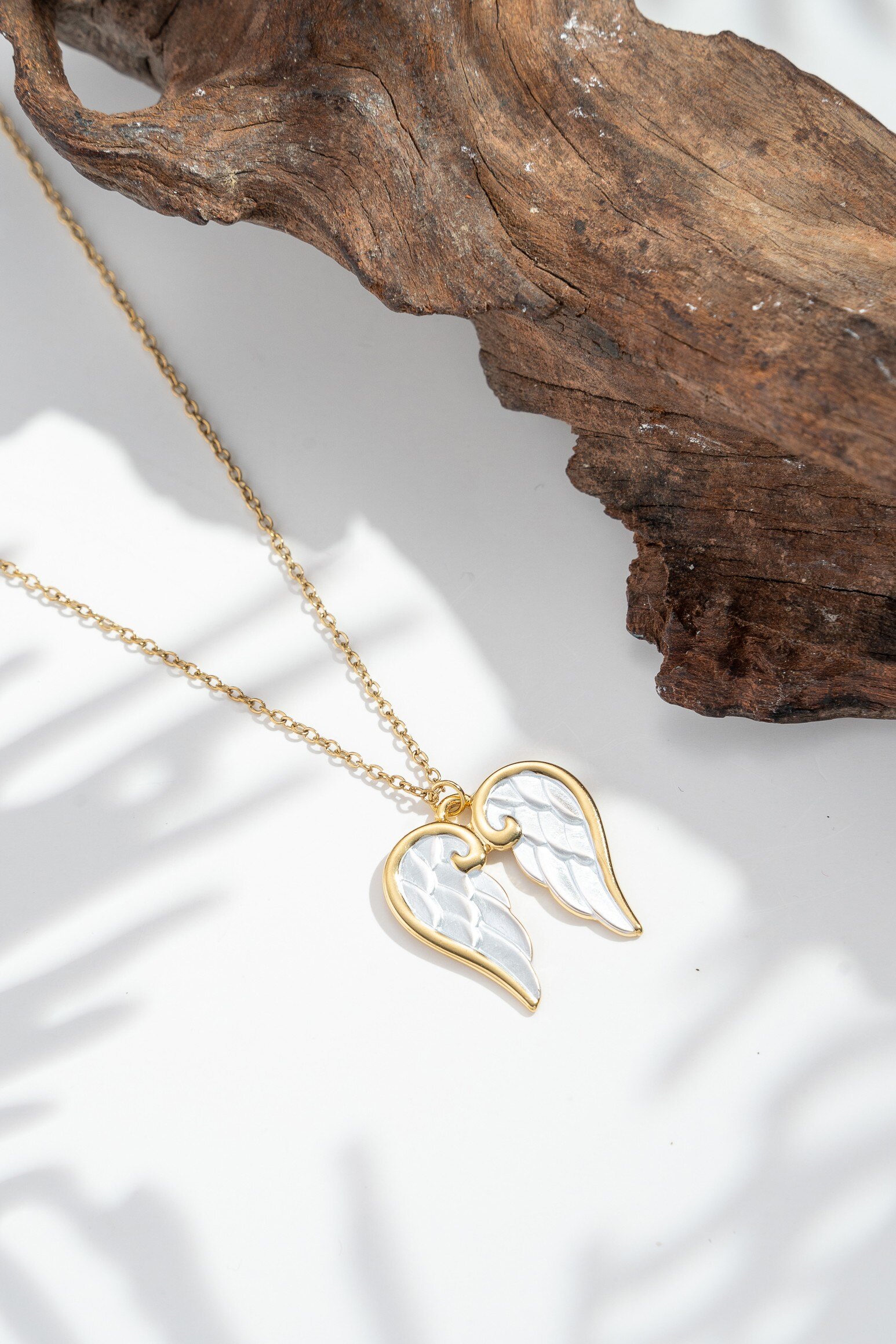 Grossista COSMOS - Collana con ali d'angelo dorate in acciaio inossidabile — cuore madreperlato e simbolismo celeste