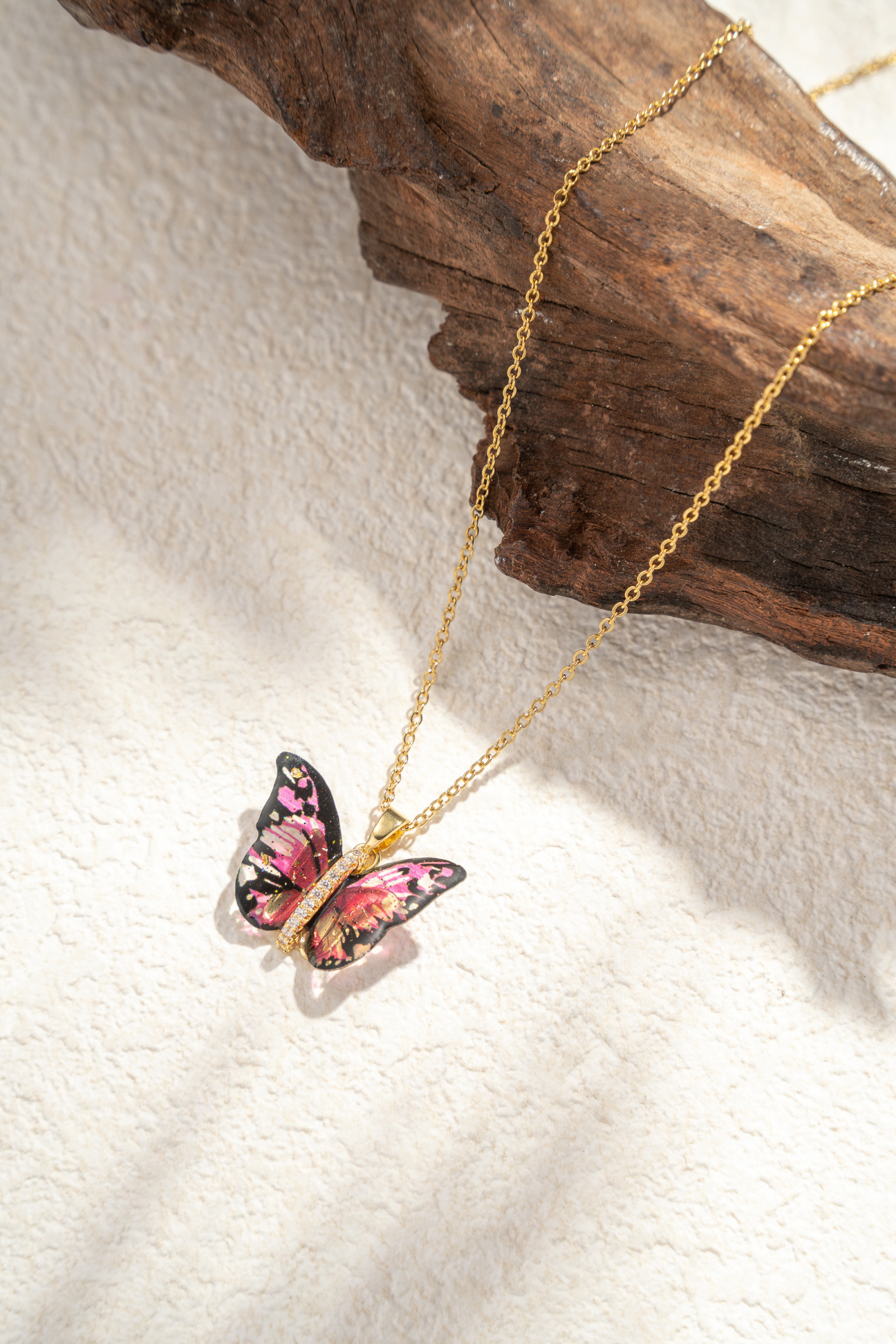 Mayorista COSMOS - Collar dorado de acero inoxidable con mariposa en tonos pastel violeta y azul con alas translúcidas
