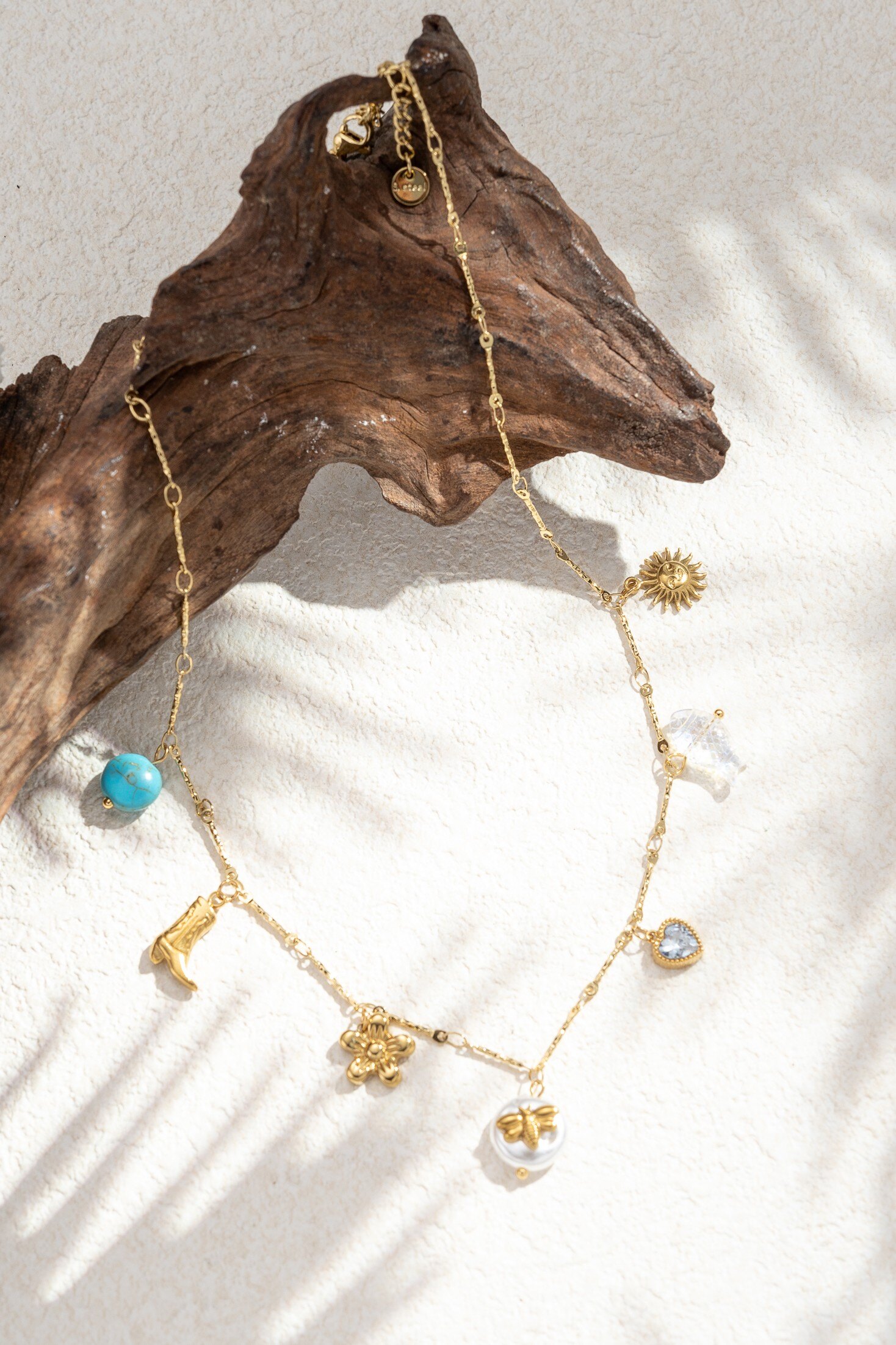 Mayorista COSMOS - Collar de charms de acero inoxidable dorado con colgantes de sol, perla, bota y piedra azul