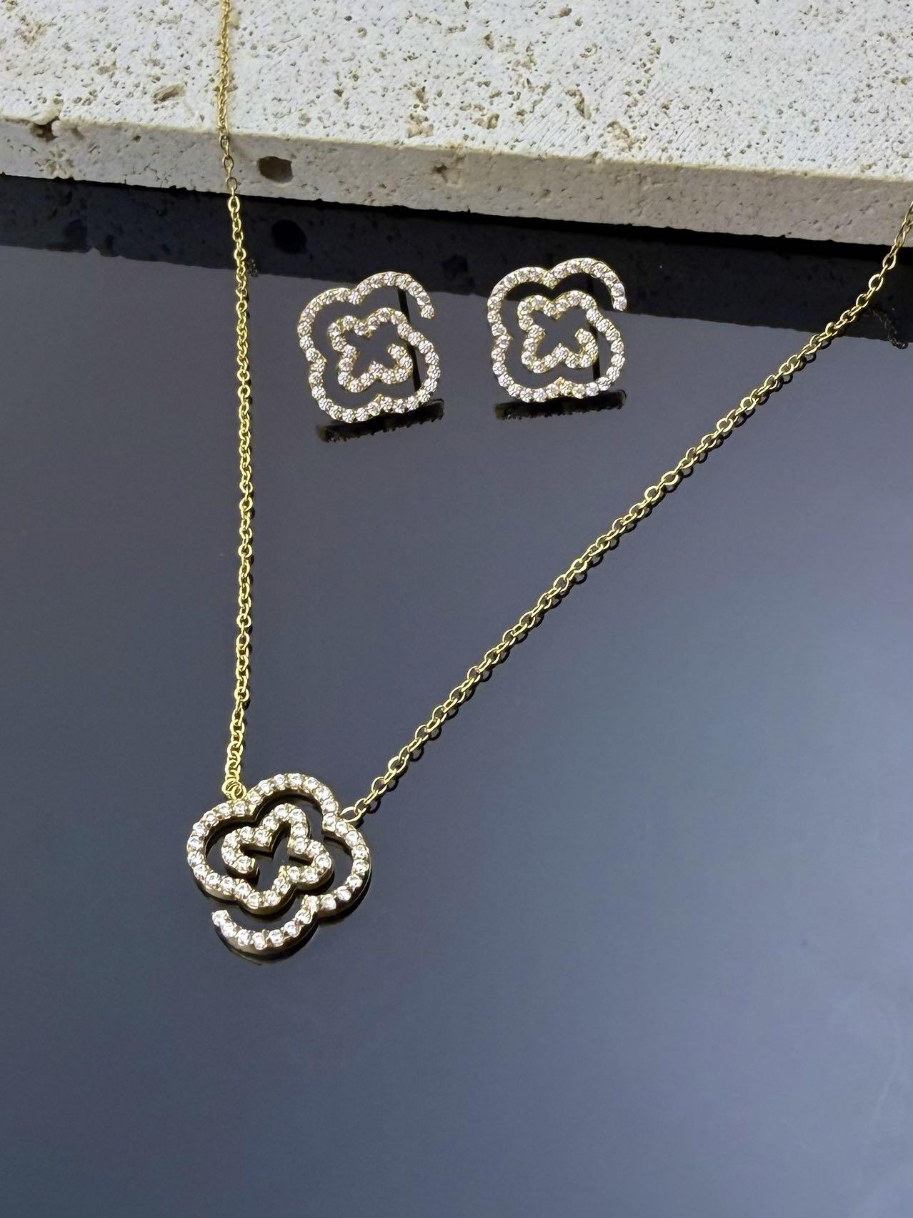Grossista COSMOS - Set collana orecchini acciaio inossidabile spirale quadrifoglio cristallo chic