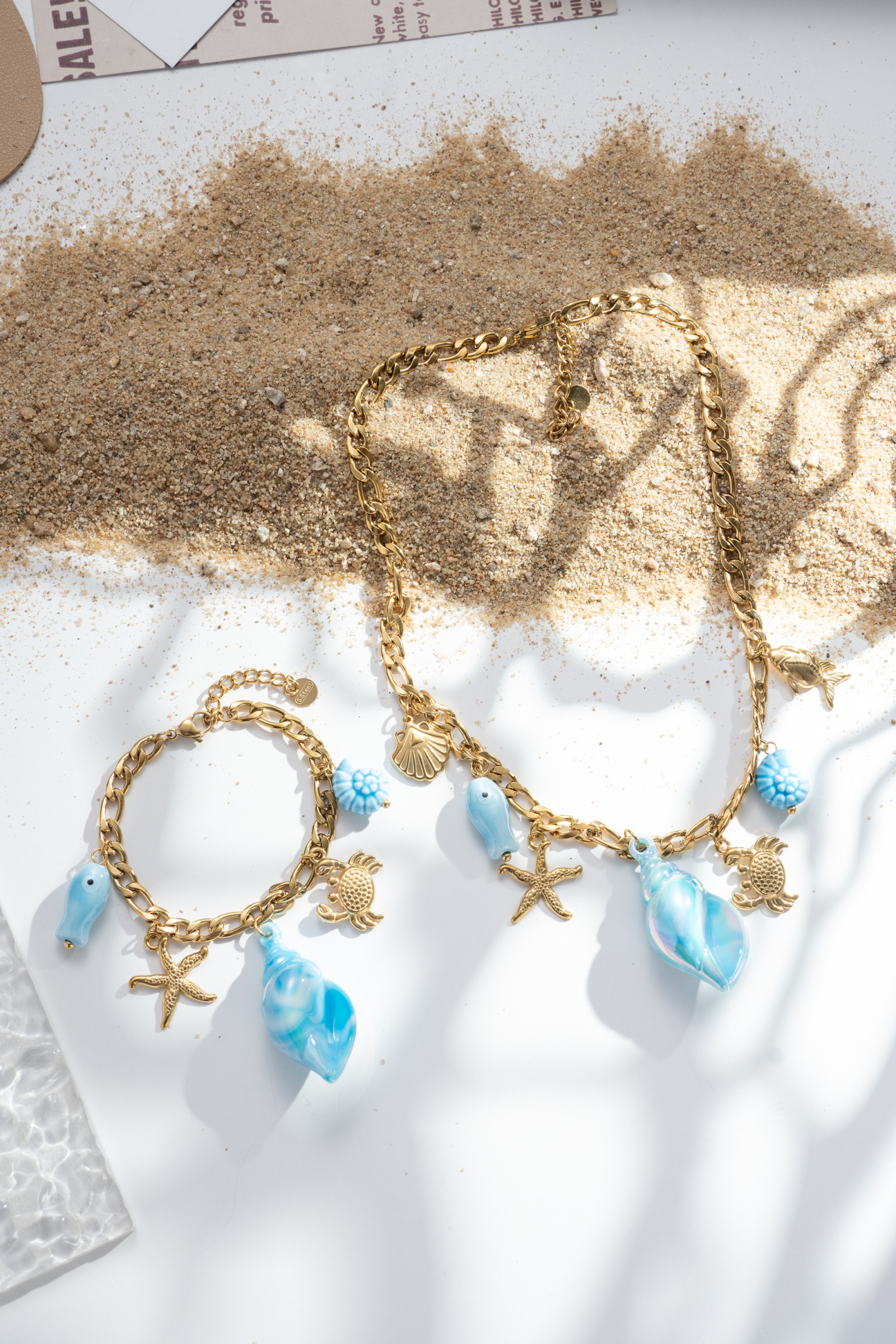 Großhändler COSMOS - Trendiges Sommer-Damenschmuckset mit goldenen Meeres-Charms und blauem Emaille-Halskette und Armband