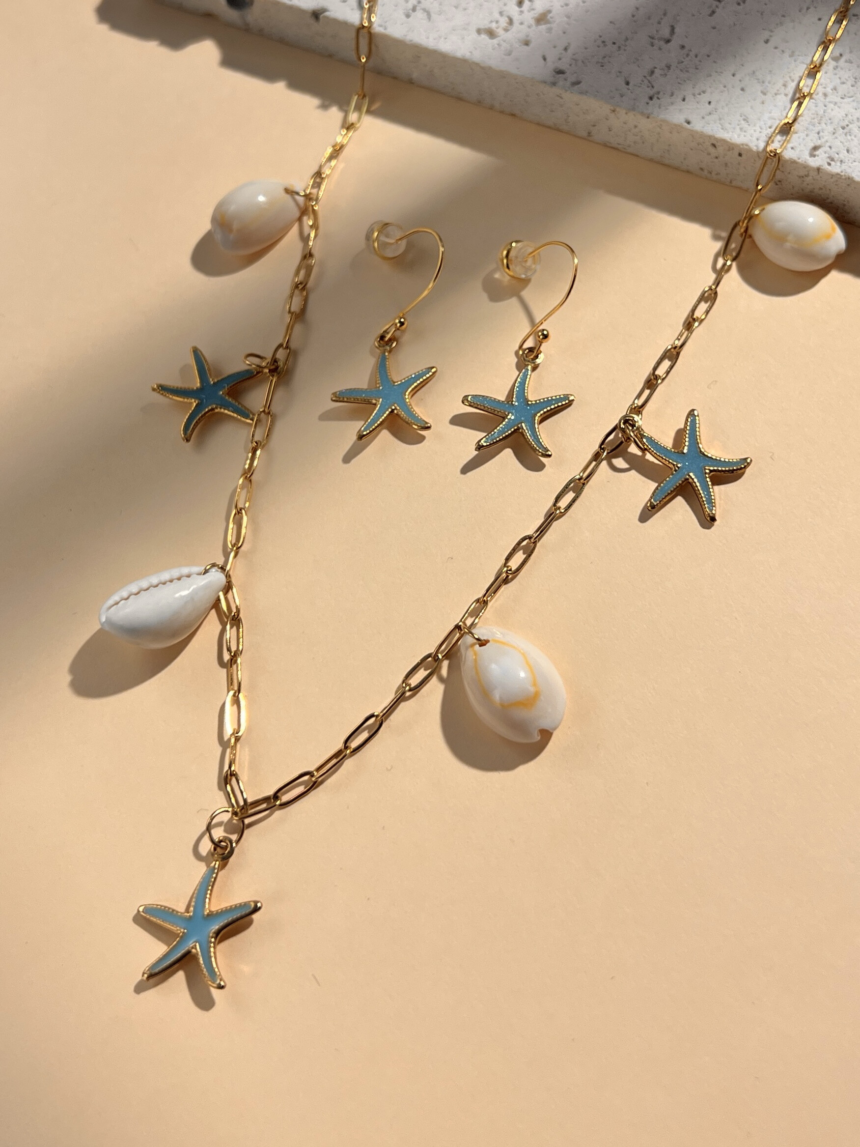 Grossiste COSMOS - Parure collier et boucle d'oreille à breloques coquillage et étoile de mer