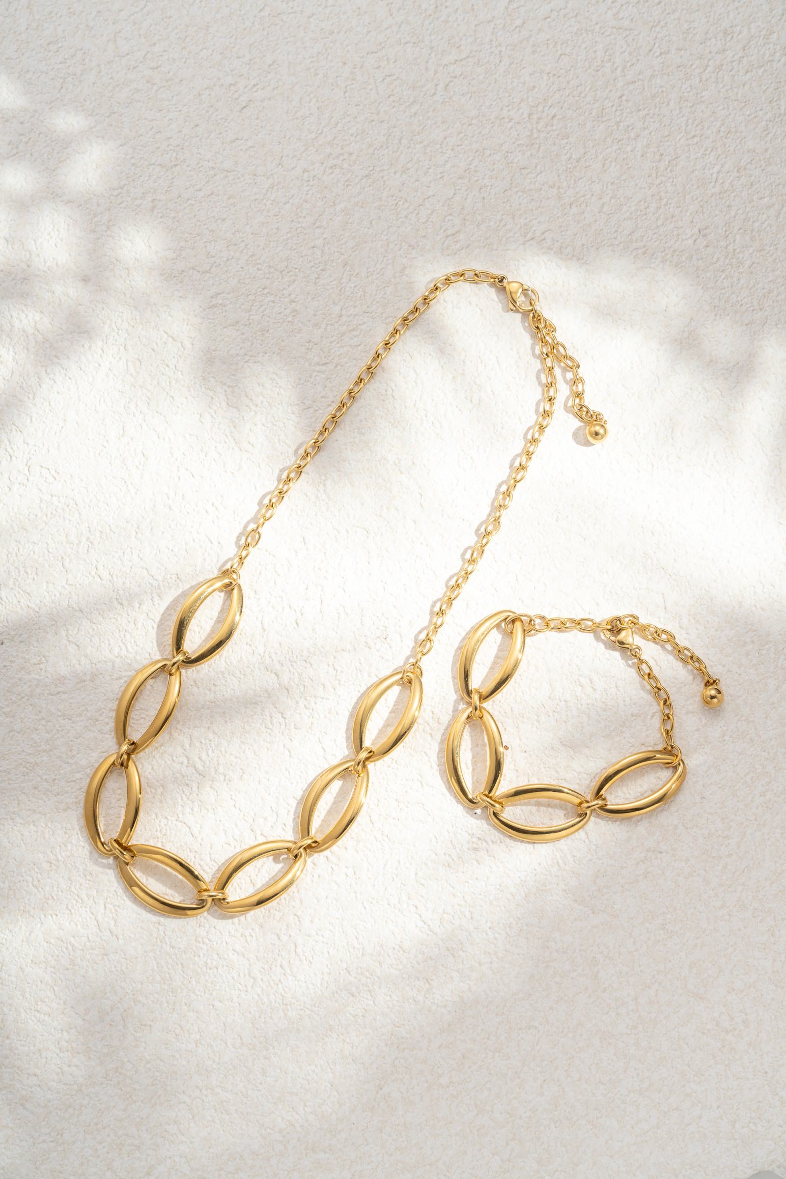 Wholesaler COSMOS - Women's gold-tone stainless steel set with necklace and bracelet featuring wide oval links for an elegant chain look