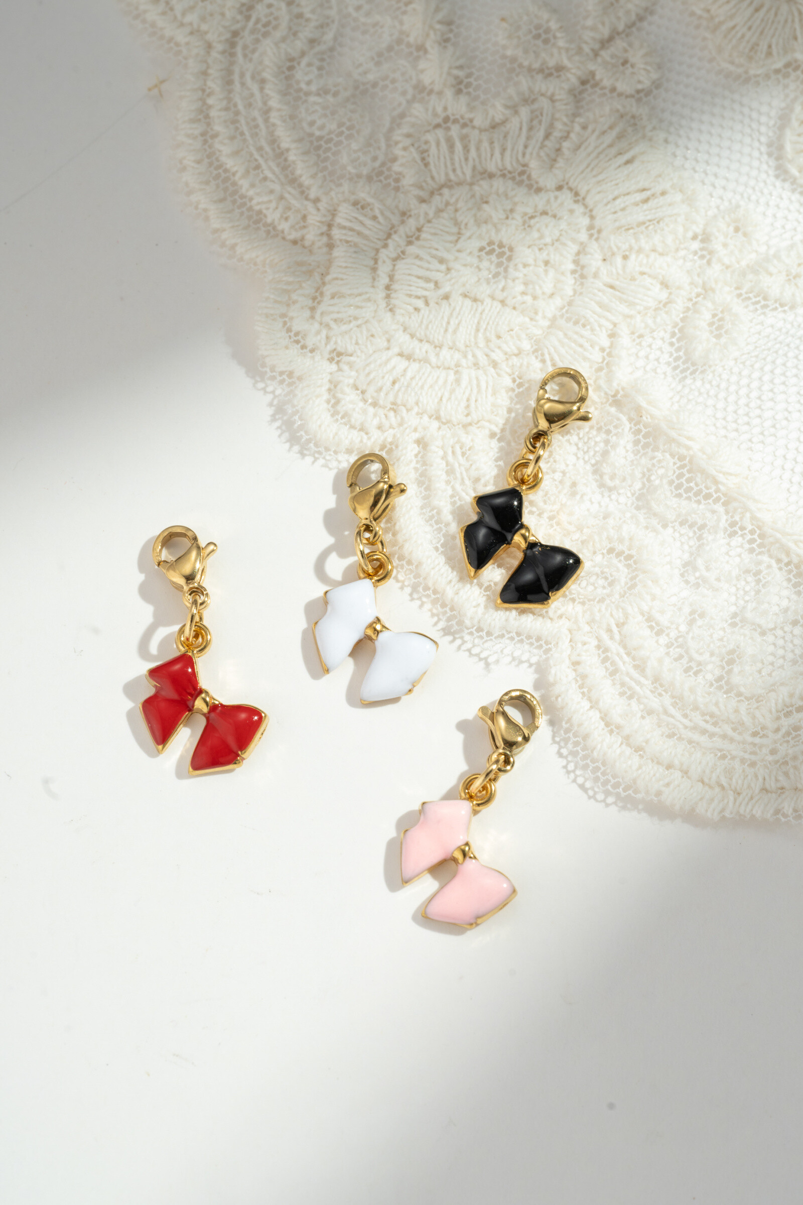 Grossiste COSMOS - Lot de 4 Pendentifs Nœud – Rouge, Rose, Noir et Blanc – Acier Inoxydable