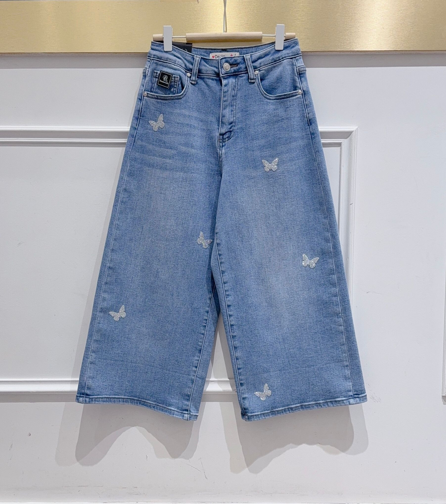 Grossista DENIM LIFE - Pantaloni cropped a gamba ampia in denim elasticizzato con farfalle paillettes