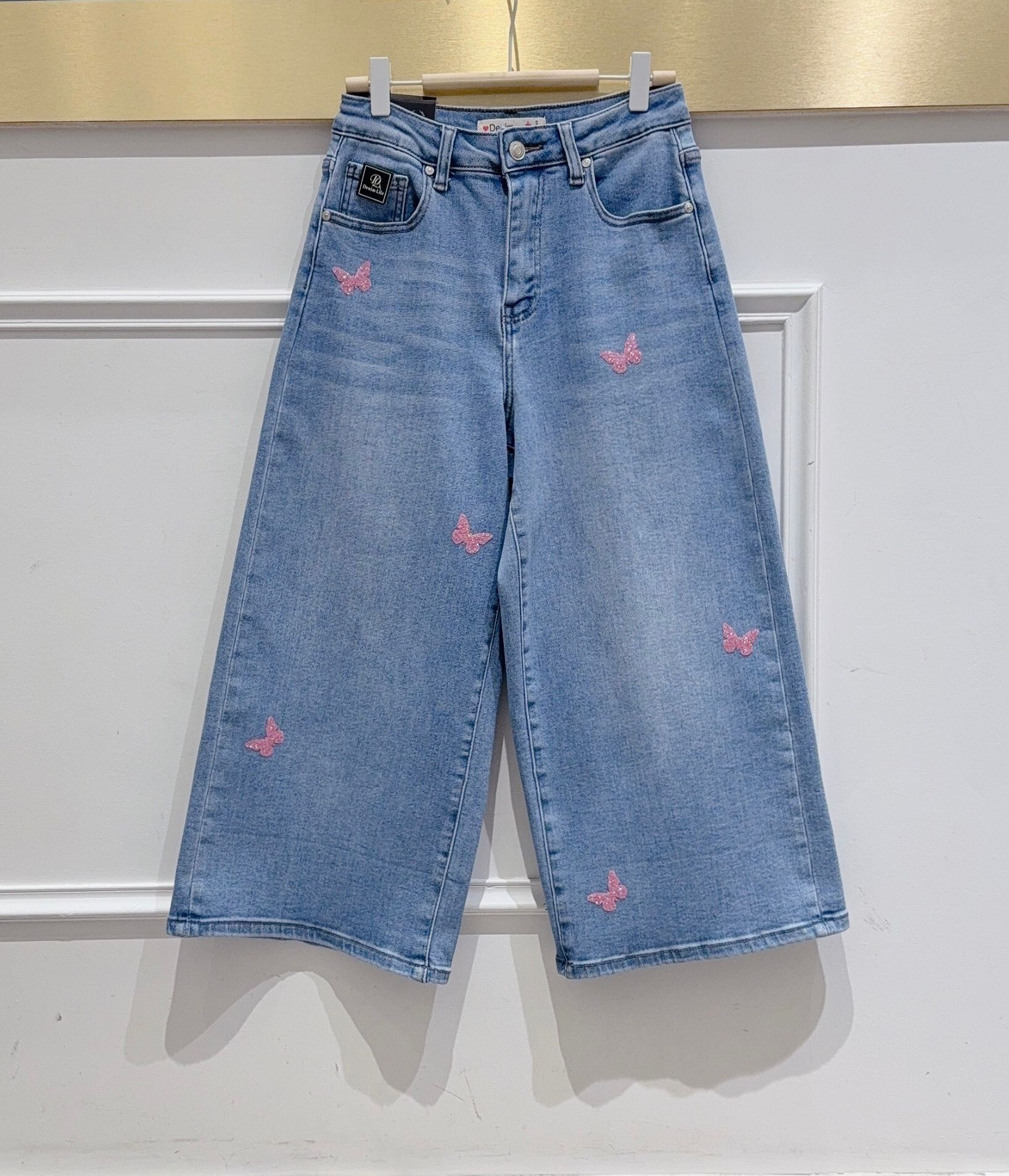 Grossista DENIM LIFE - Pantaloni cropped a gamba ampia in denim elasticizzato con farfalle paillettes